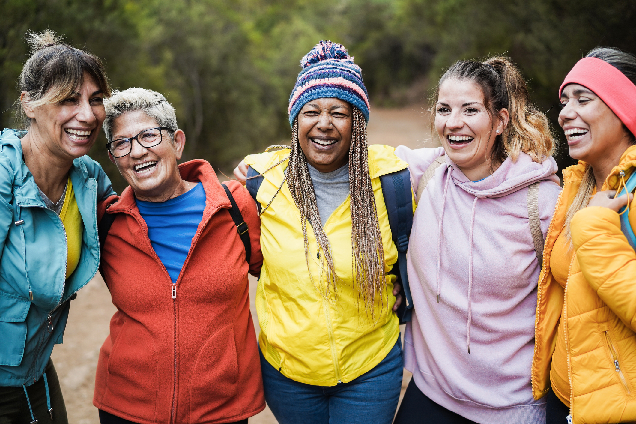 A group of women smiling and laughing on a hike