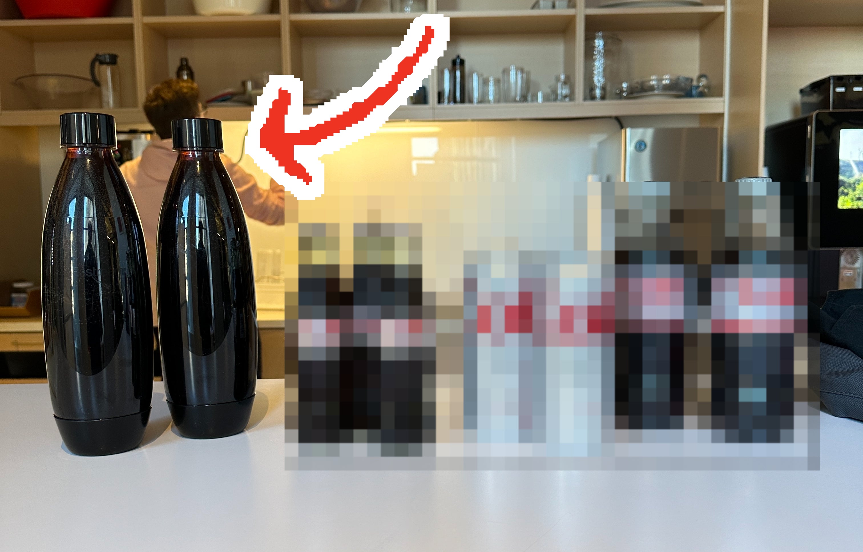 The four different types of Diet Coke lined up on a table, with an arrow pointing to the SodaStream bottles