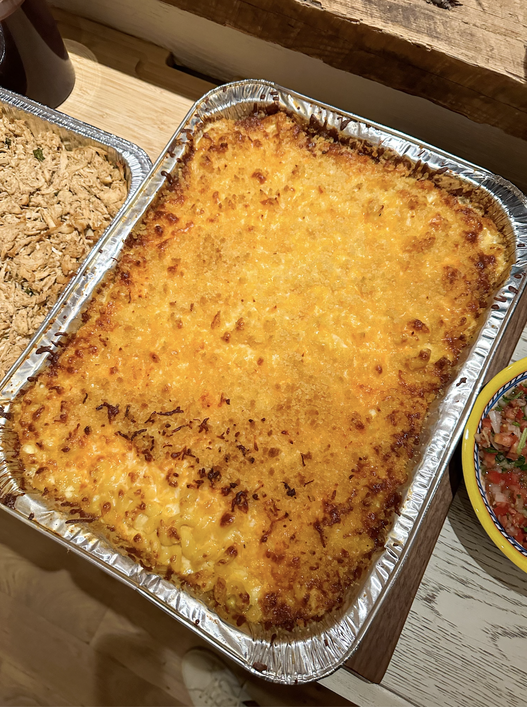 A large disposable tin filled with a huge portion of baked mac &#x27;n&#x27; cheese
