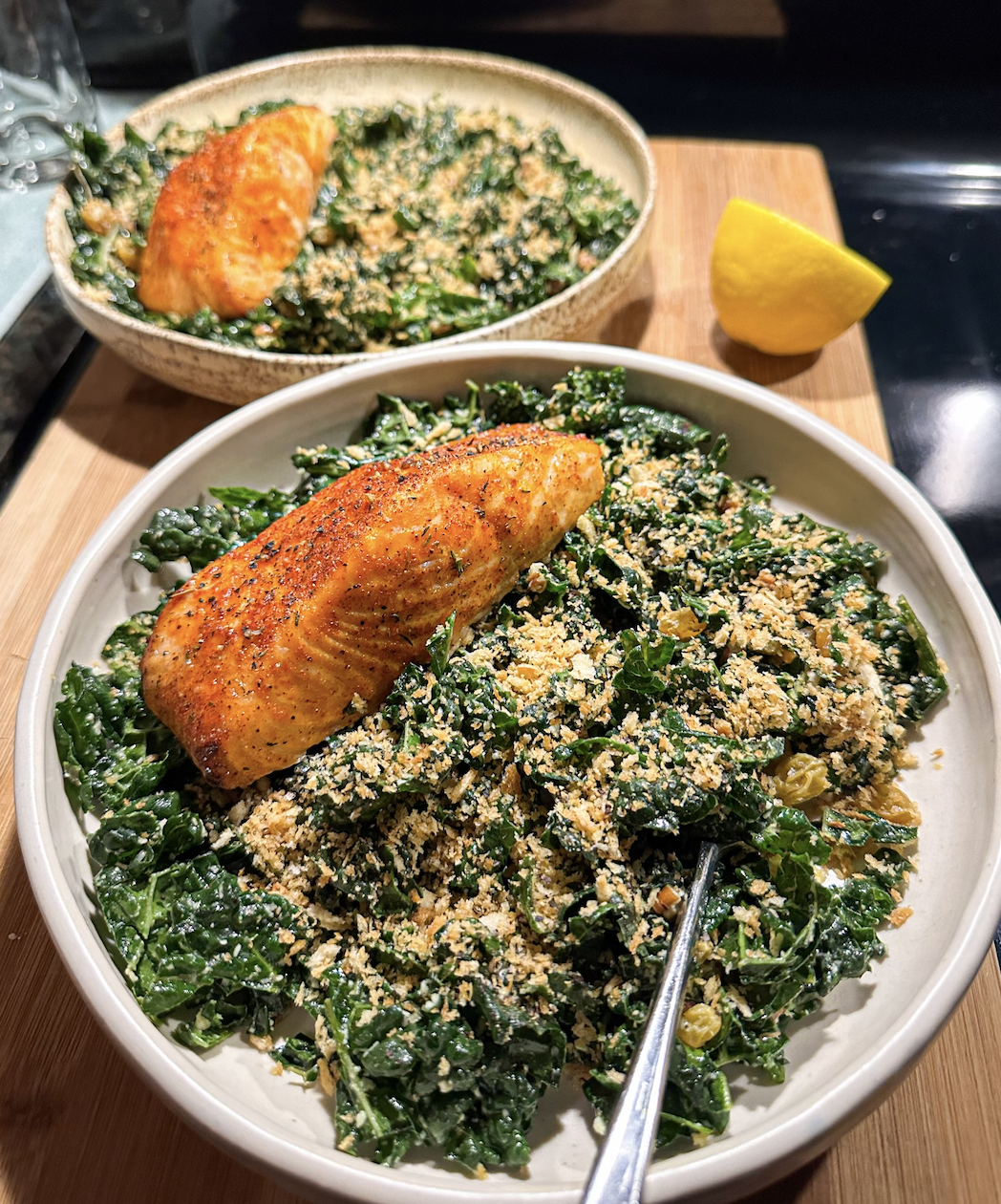 Salad topped with cheese, bread crumbs, and air-fried salmon