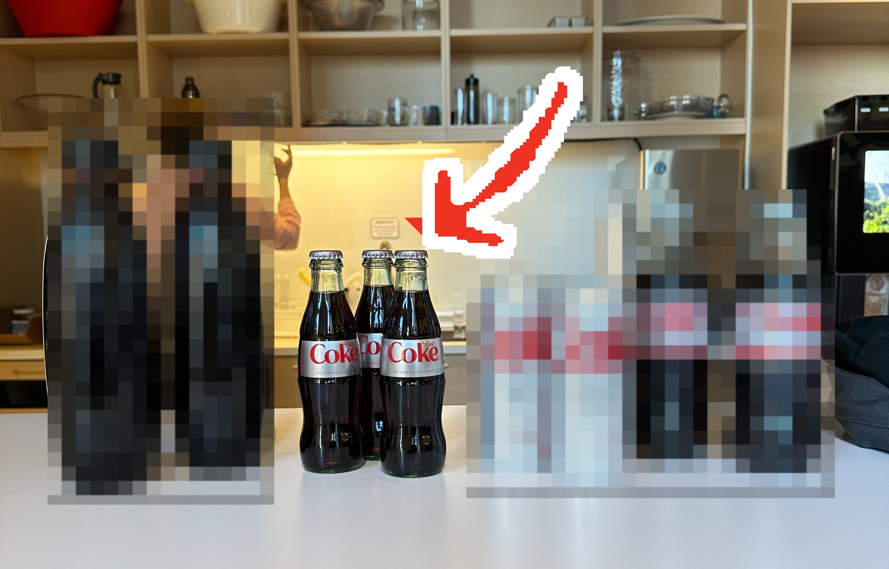 The four different types of Diet Coke lined up on a table, with an arrow pointing to the glass bottle