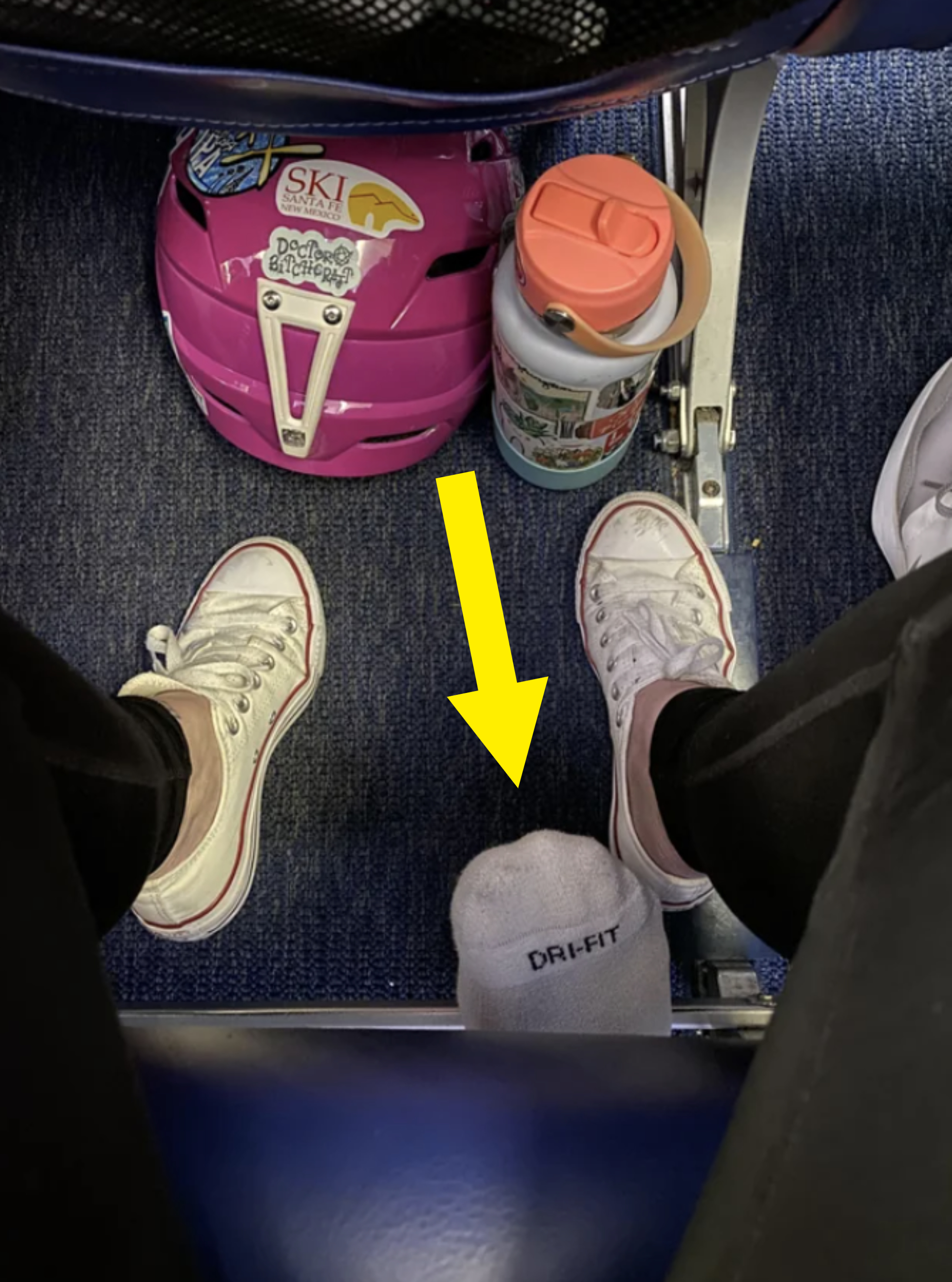 a person&#x27;s foot under someone else&#x27;s airplane seat