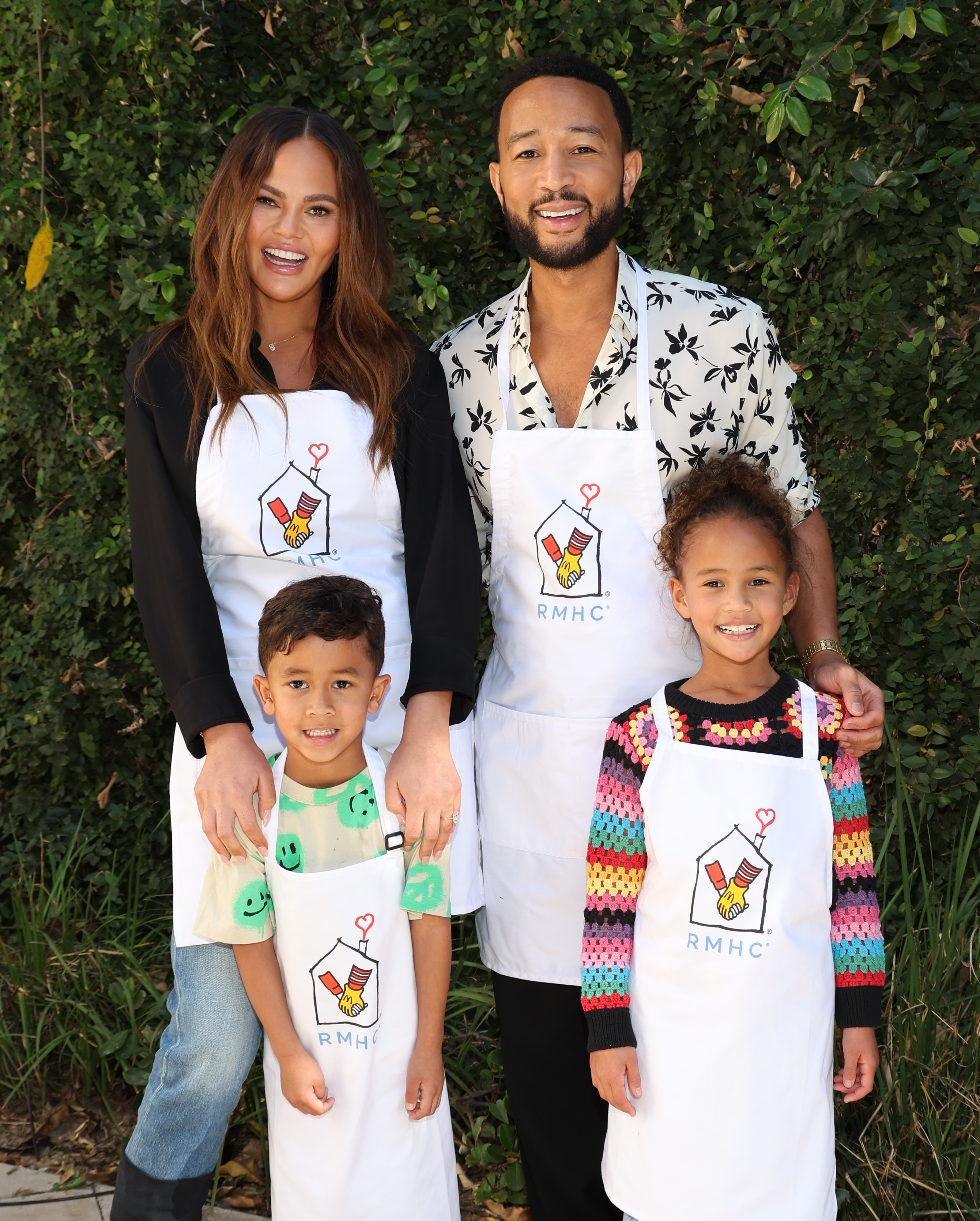 chrissy and john with their two oldest kids, all wearing aprons to volunteer