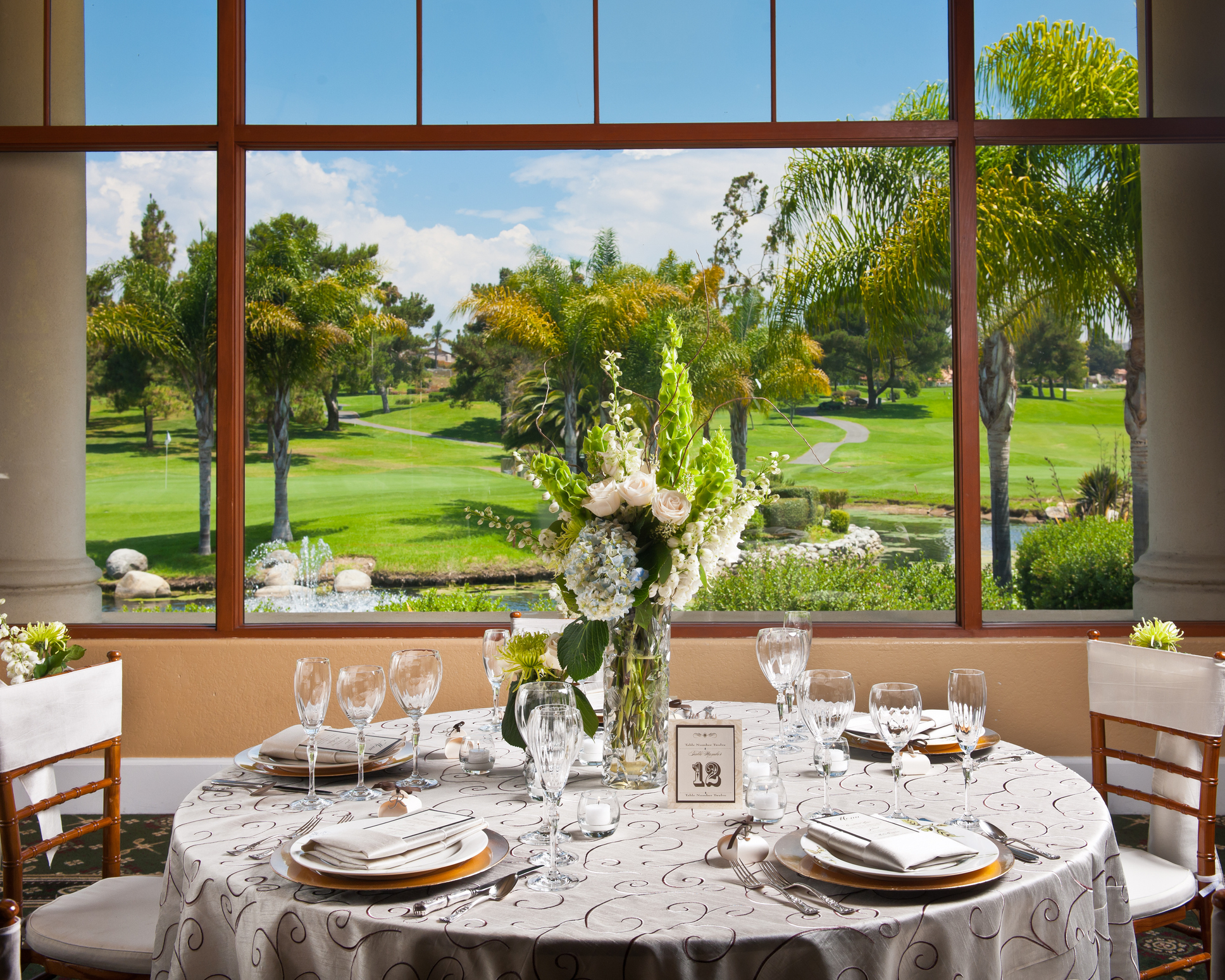 set up table in a country club with a golf course seen through the windows