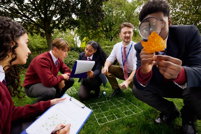 A teacher and his students are outside conducting a science lesson