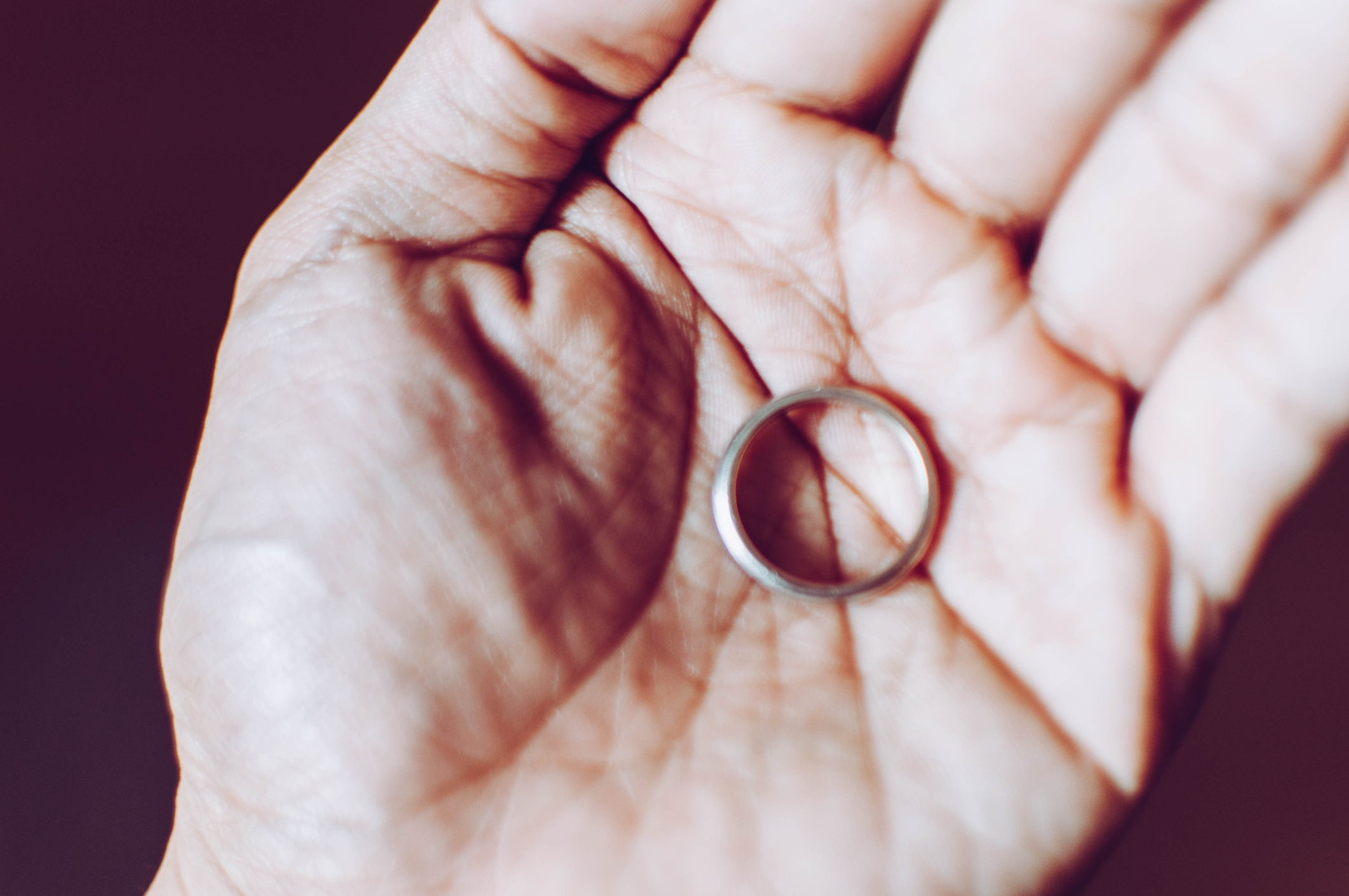 a hand holding a wedding band