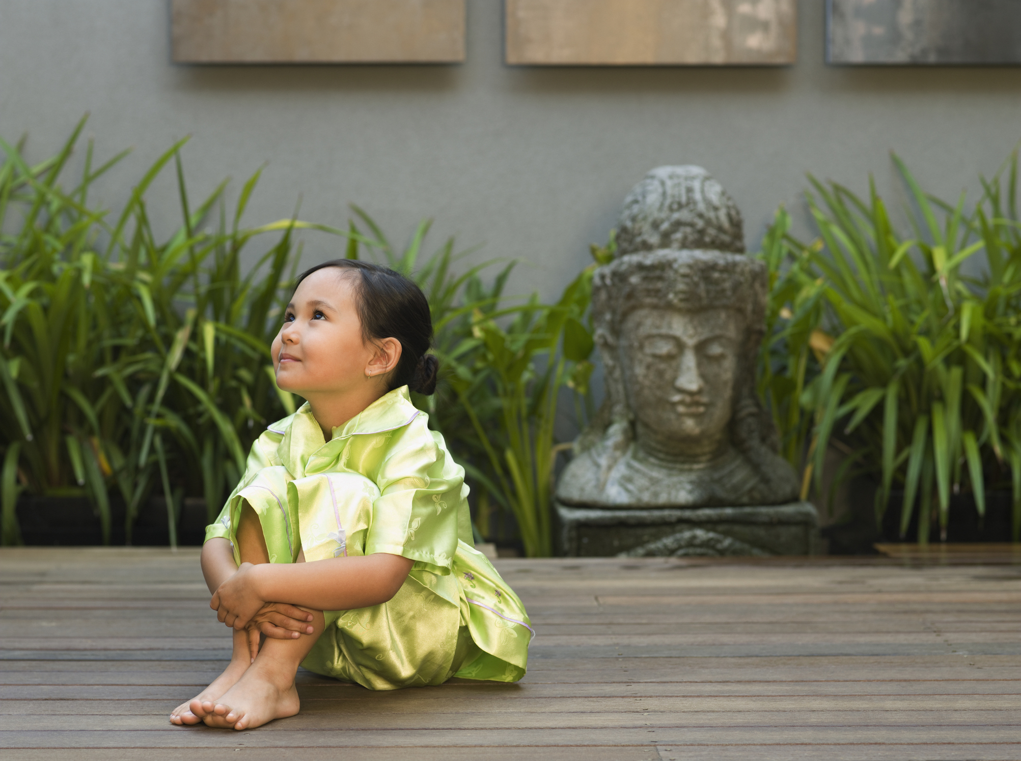 A little girl sitting on an outside deck
