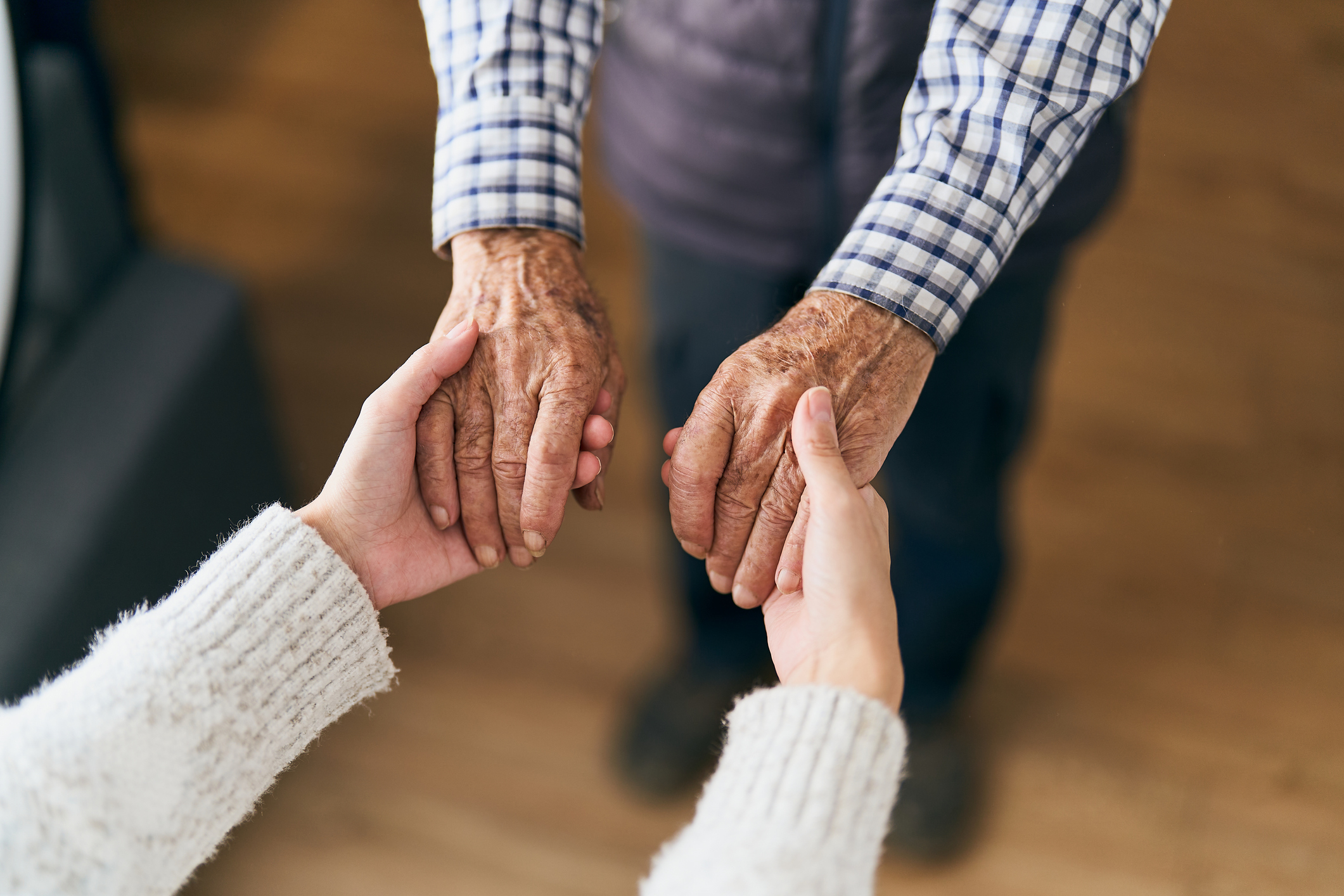 Older man holding the hands of a young woman with the concept of home care