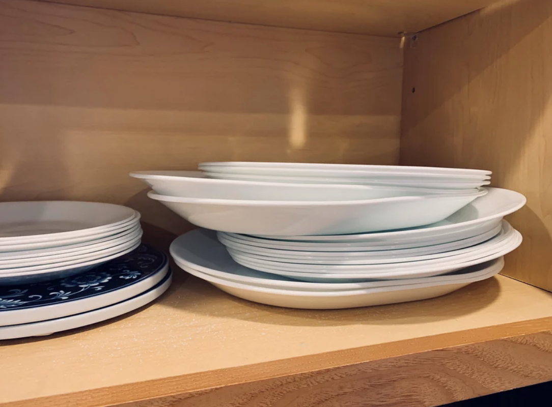 disorganized plates in a cupboard