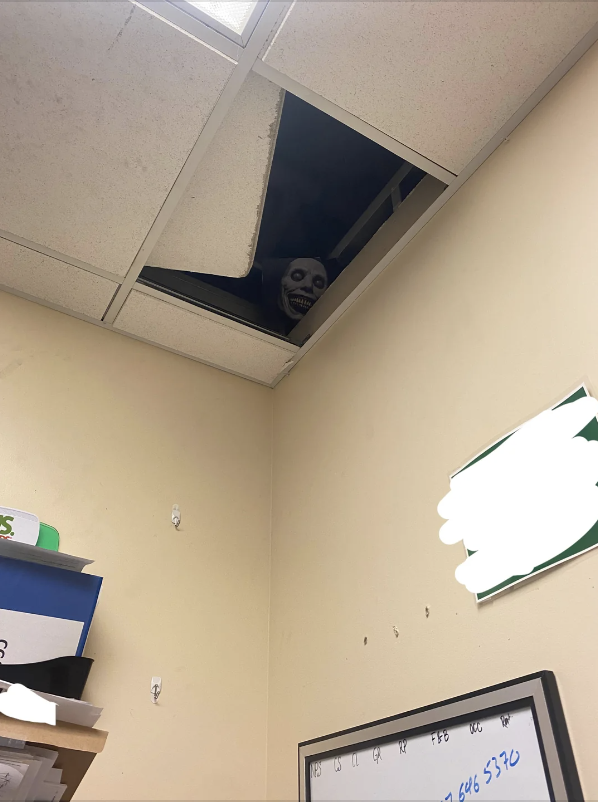 a scary mask in a ceiling tile