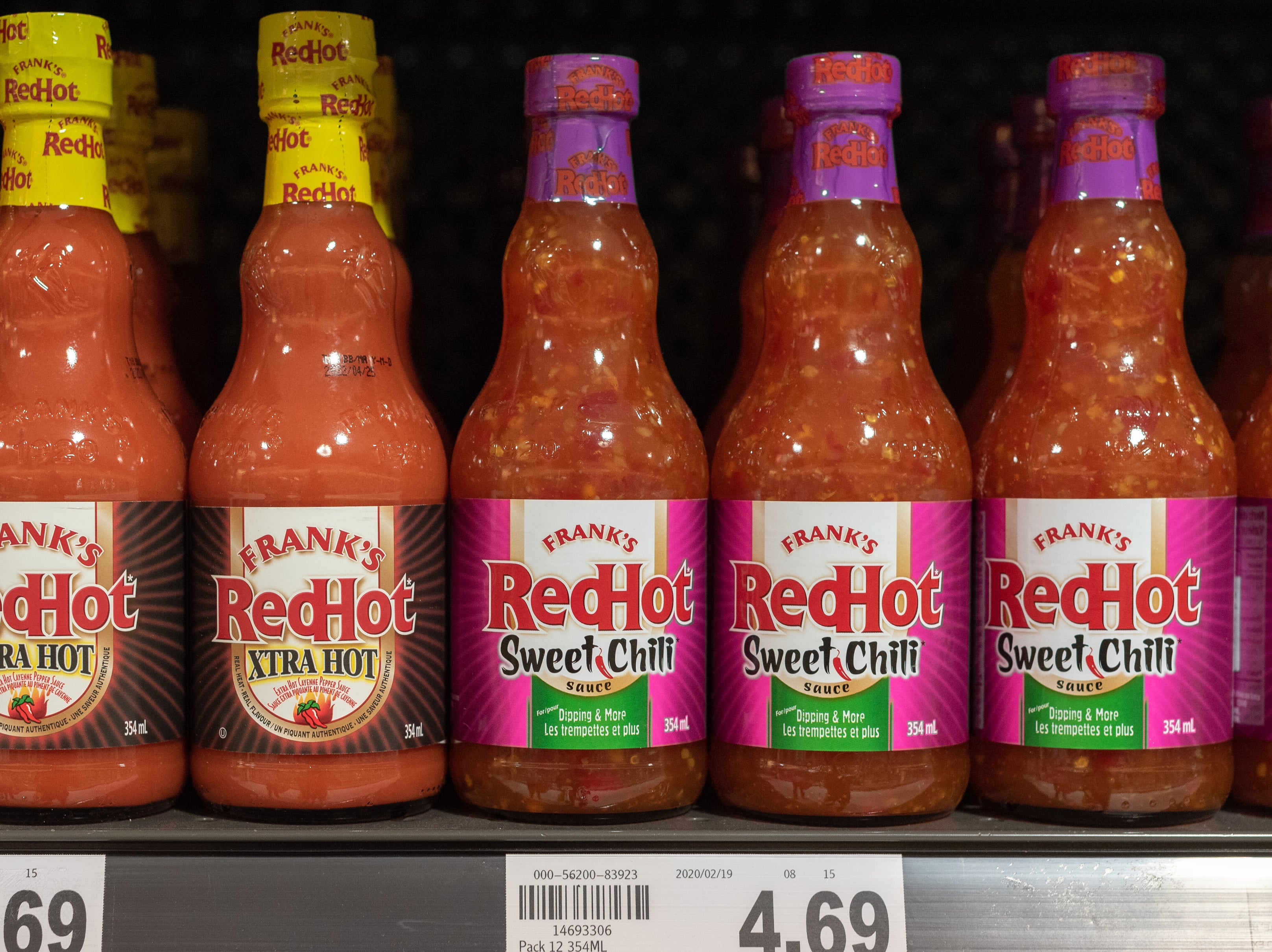 Bottles of Frank&#x27;s RedHot Xtra Hot and Sweet Chili on a store shelf