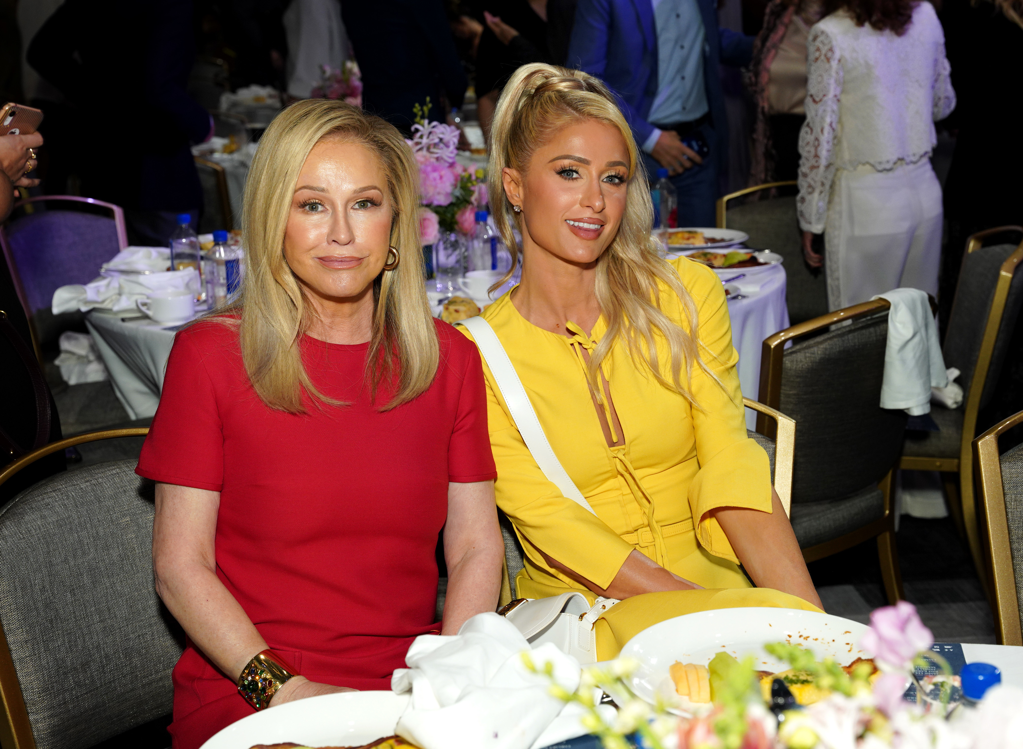 Kathy and Paris sitting at a dinner table at an event