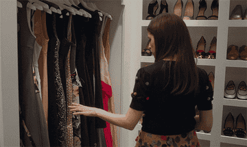 Stephanie from a Simple Favor running her hand over gorgeous clothes in huge closet