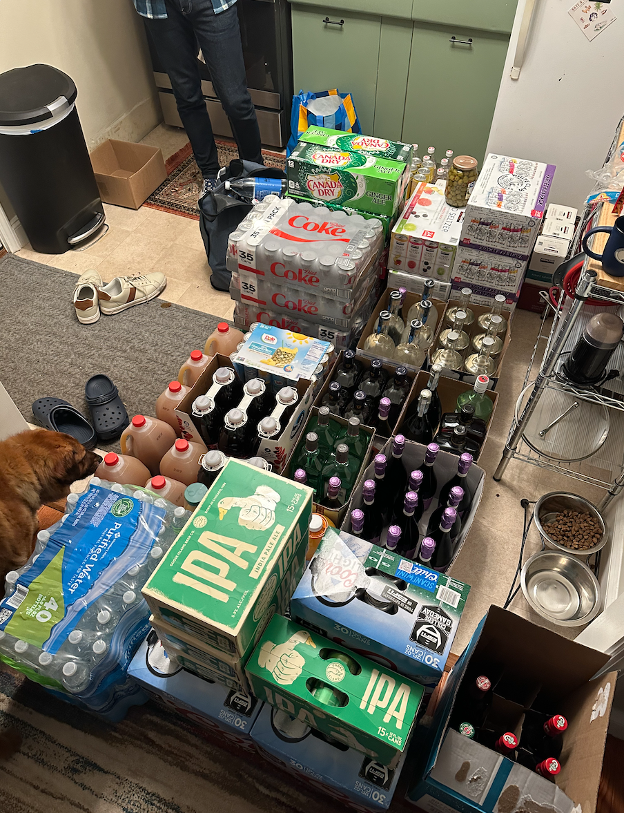 Author&#x27;s small kitchen that&#x27;s almost entirely covered with sodas, beer, wine, and other beverages in cases for his wedding