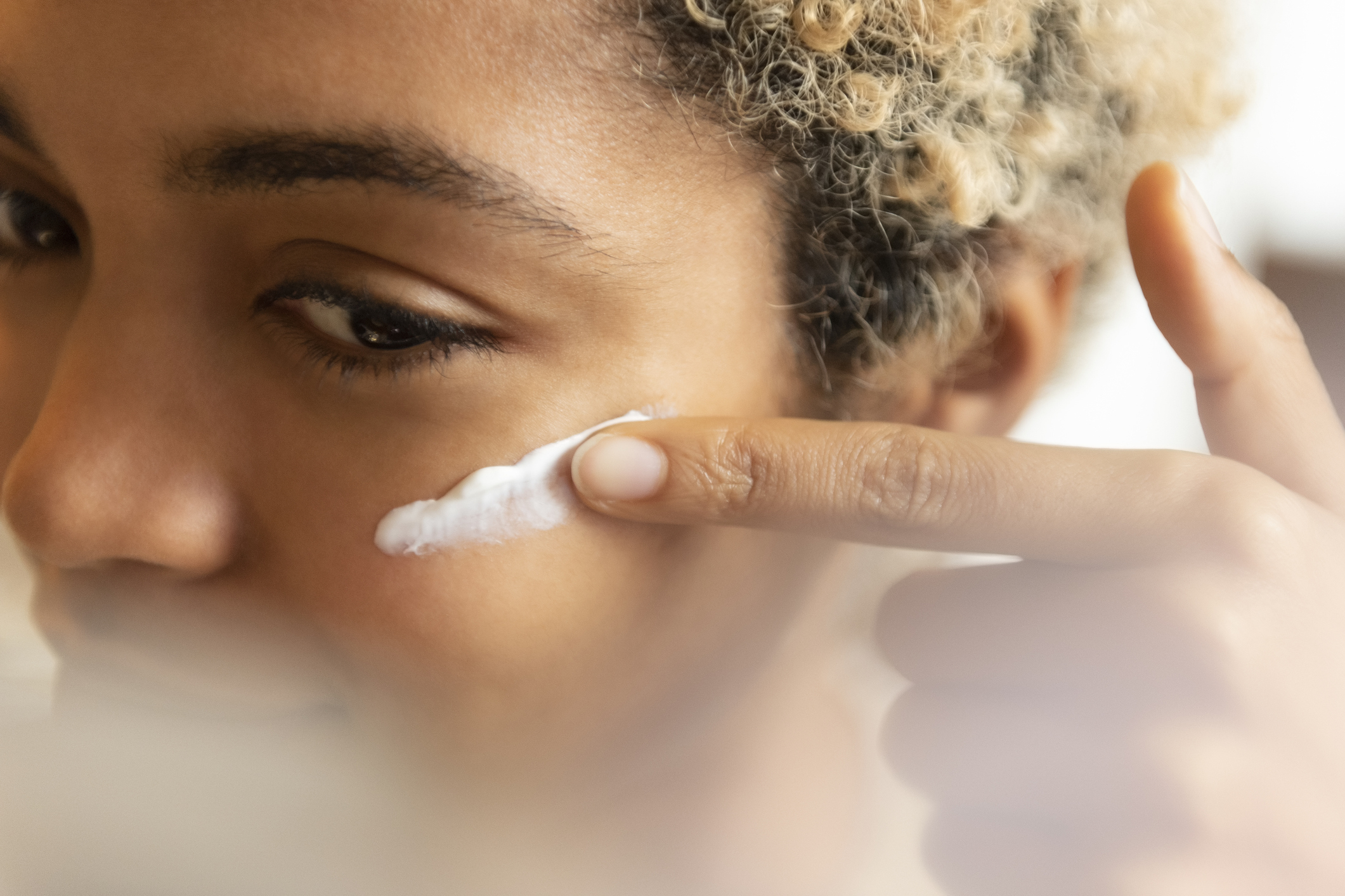 a woman applying cream to her face