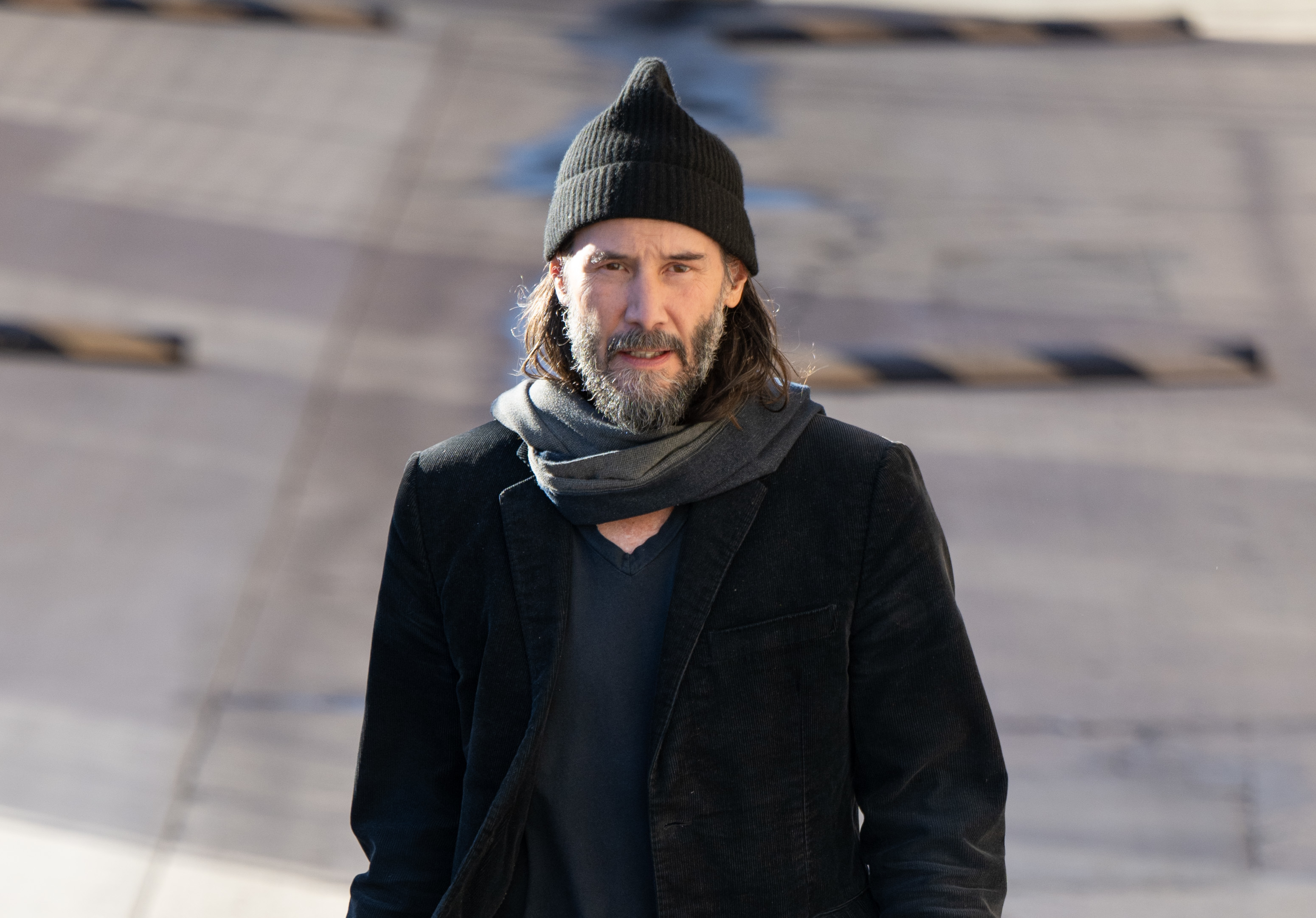Close-up of Keanu in a hat, scarf, and coat