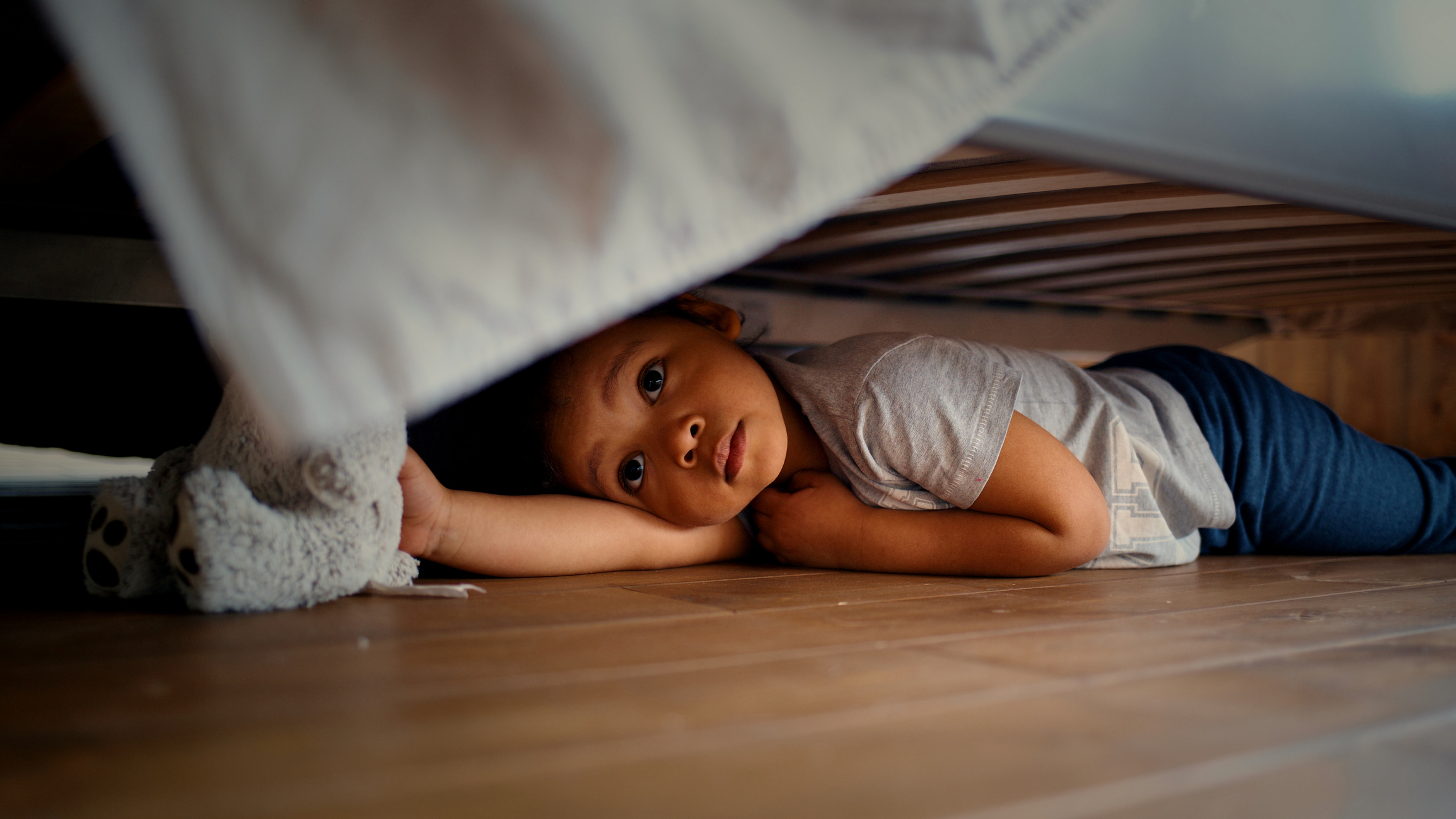 kid hiding under the bed