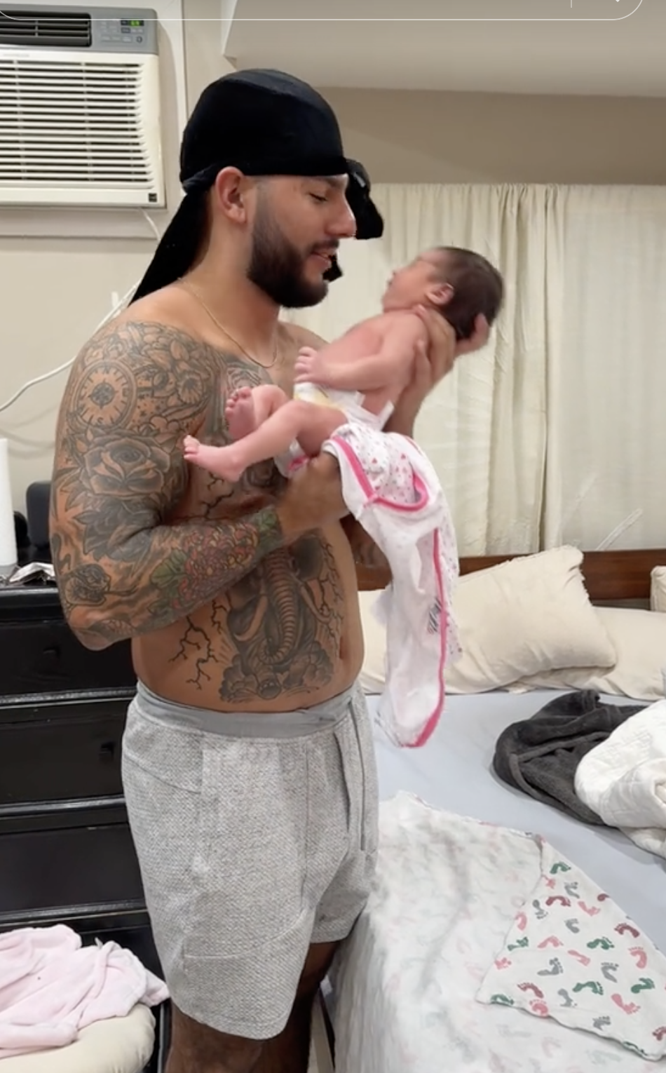 he&#x27;s holding his baby before she&#x27;s in her swaddle