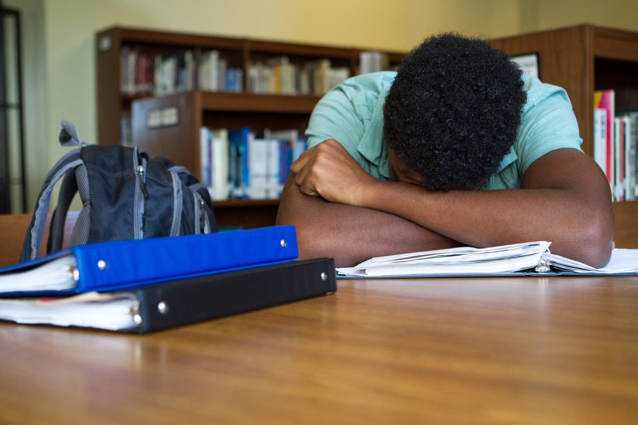 Student overwhelmed with homework at a library