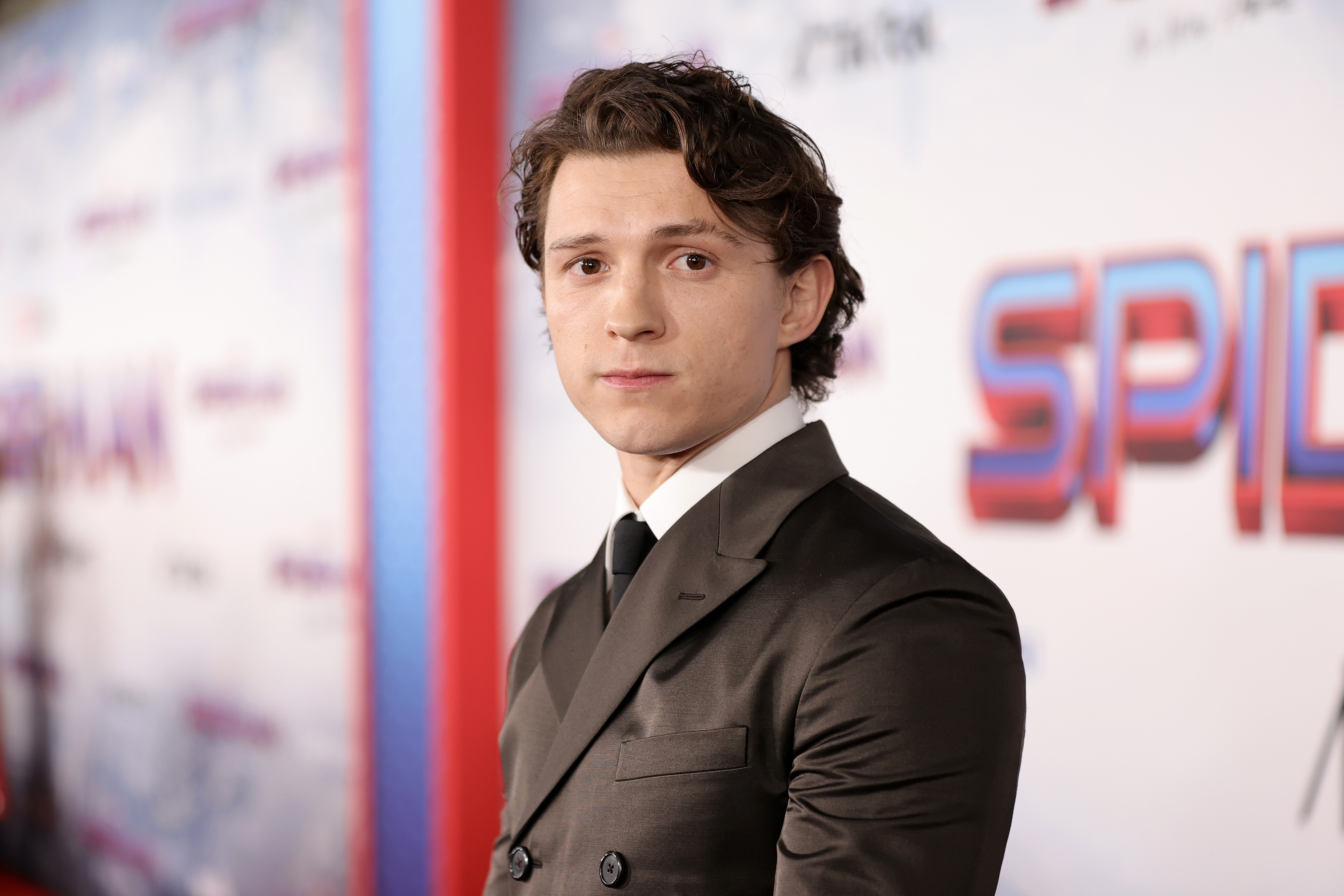 Close-up of Tom Holland in a suit and tie at a media event