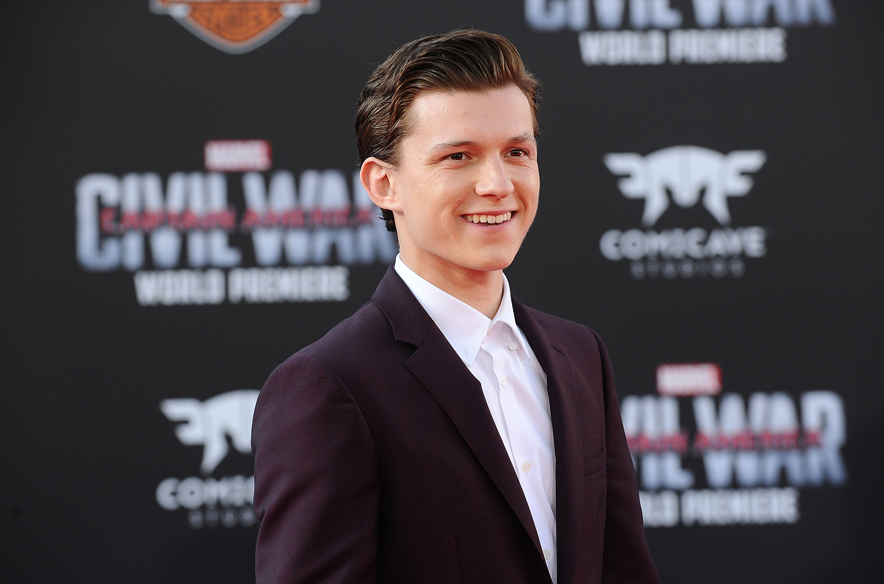 Close-up of Tom Holland smiling at a media event