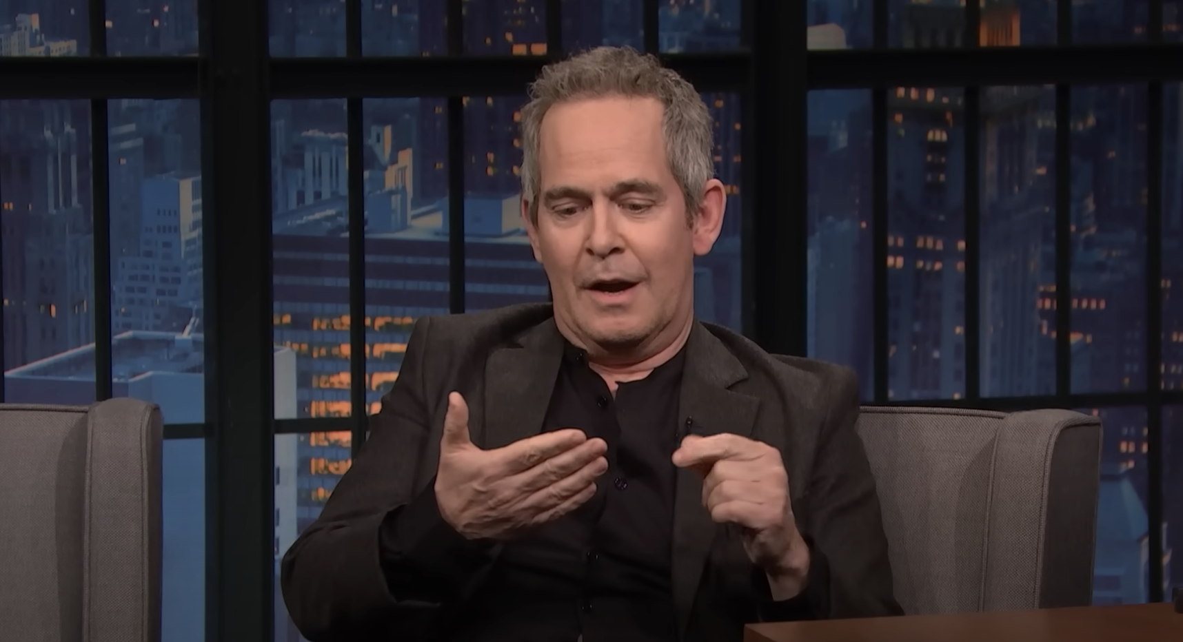 Close-up of Tom Hollander on the talk show
