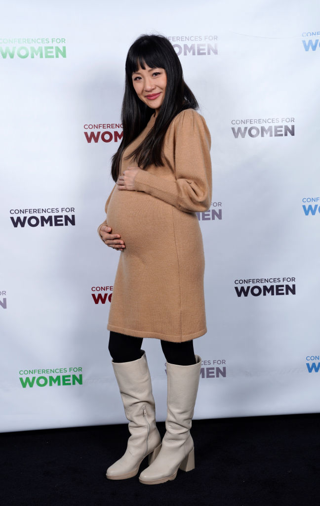 constance holding her pregnant belly at an event