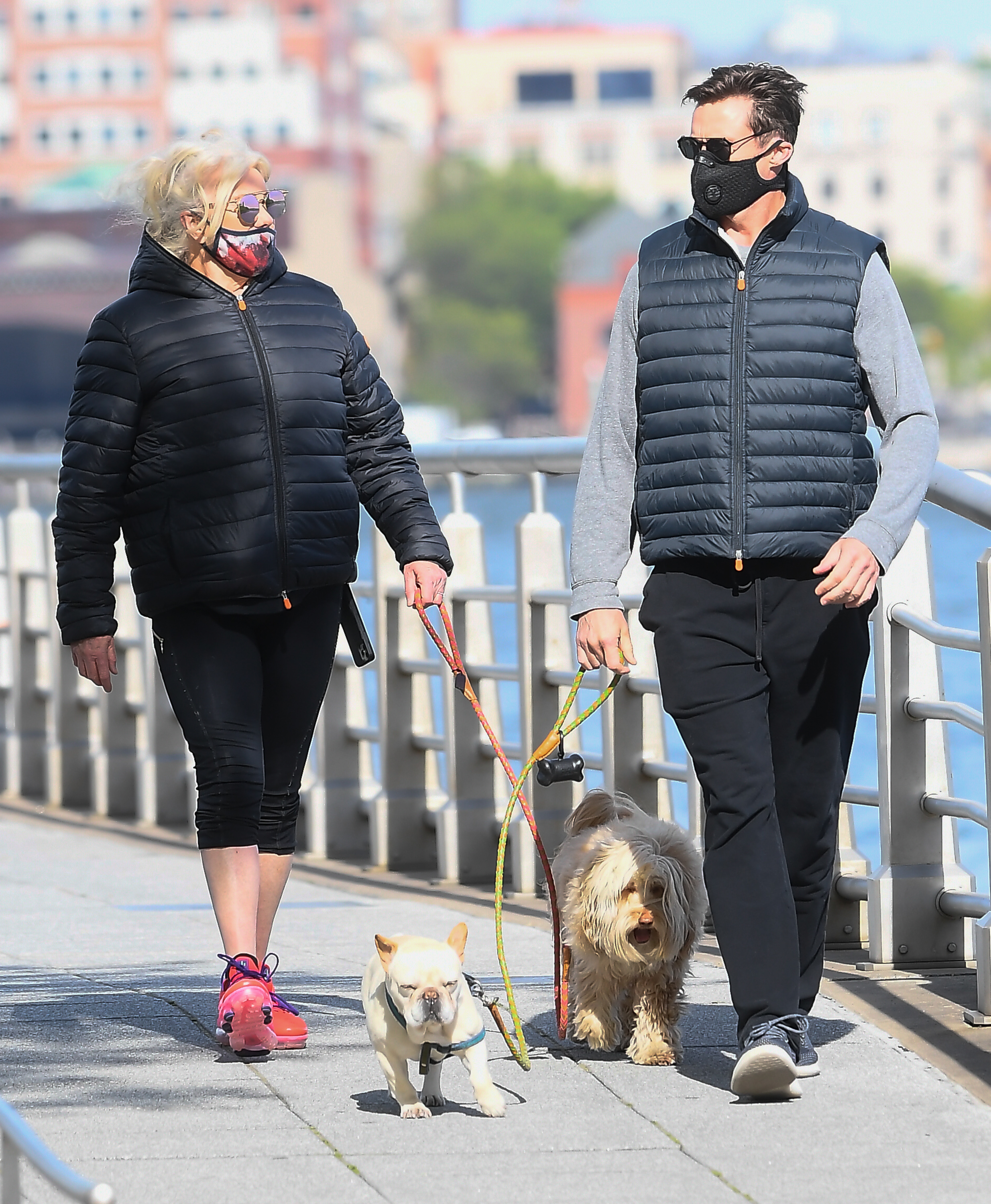 the two walking their dogs while wearing masks