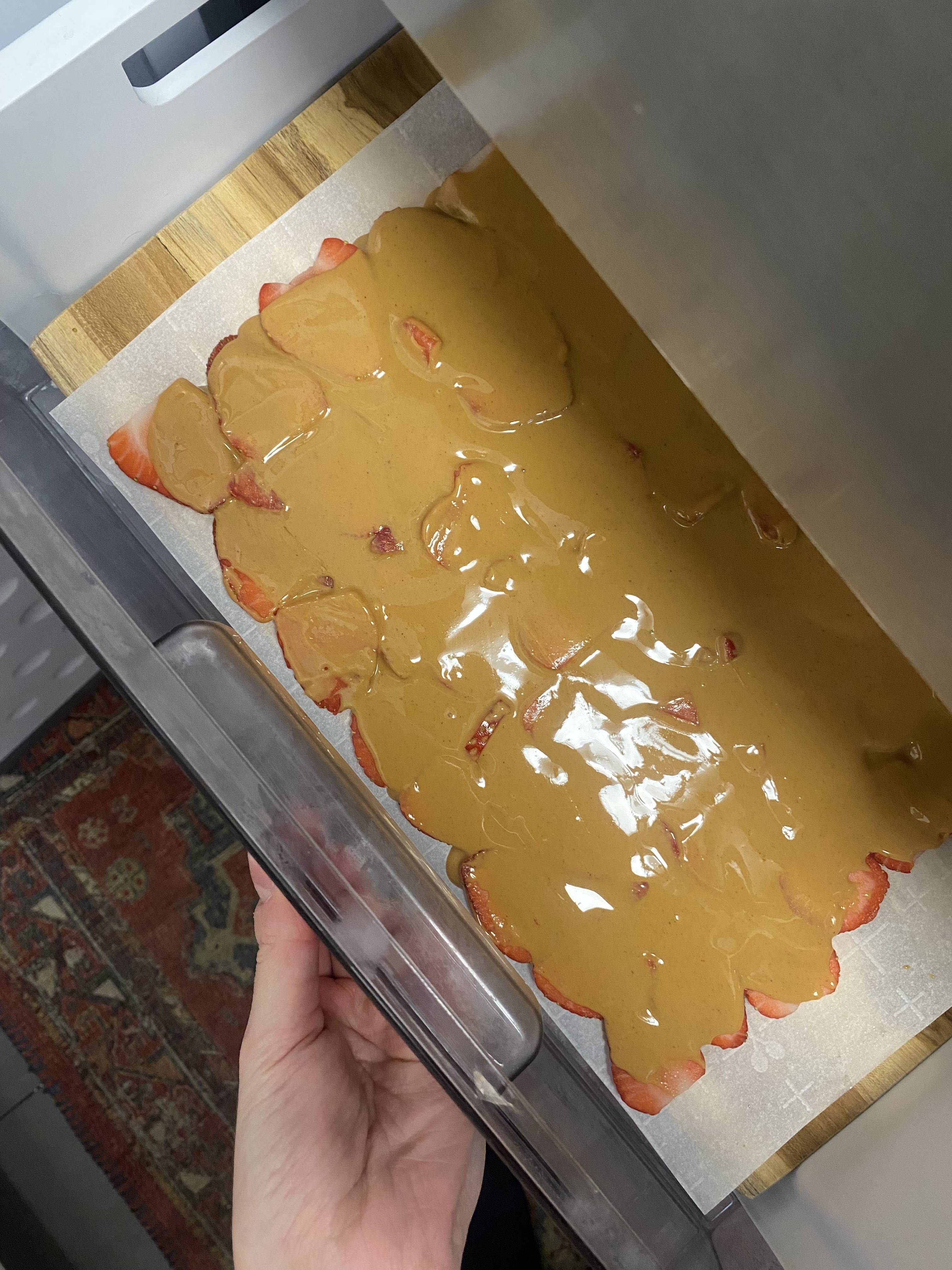 The strawberry peanut butter layer being put in a freezer