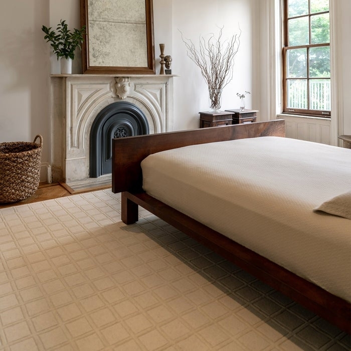 an ivory hand-carved tufted rug in a bedroom