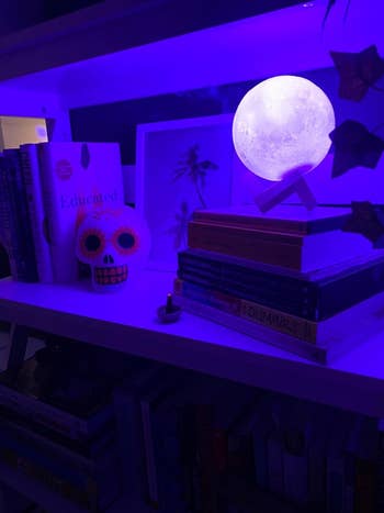 the moon glowing purple on a bookshelf