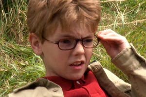 Thomas Brodie-Sangster as a young boy in glasses.