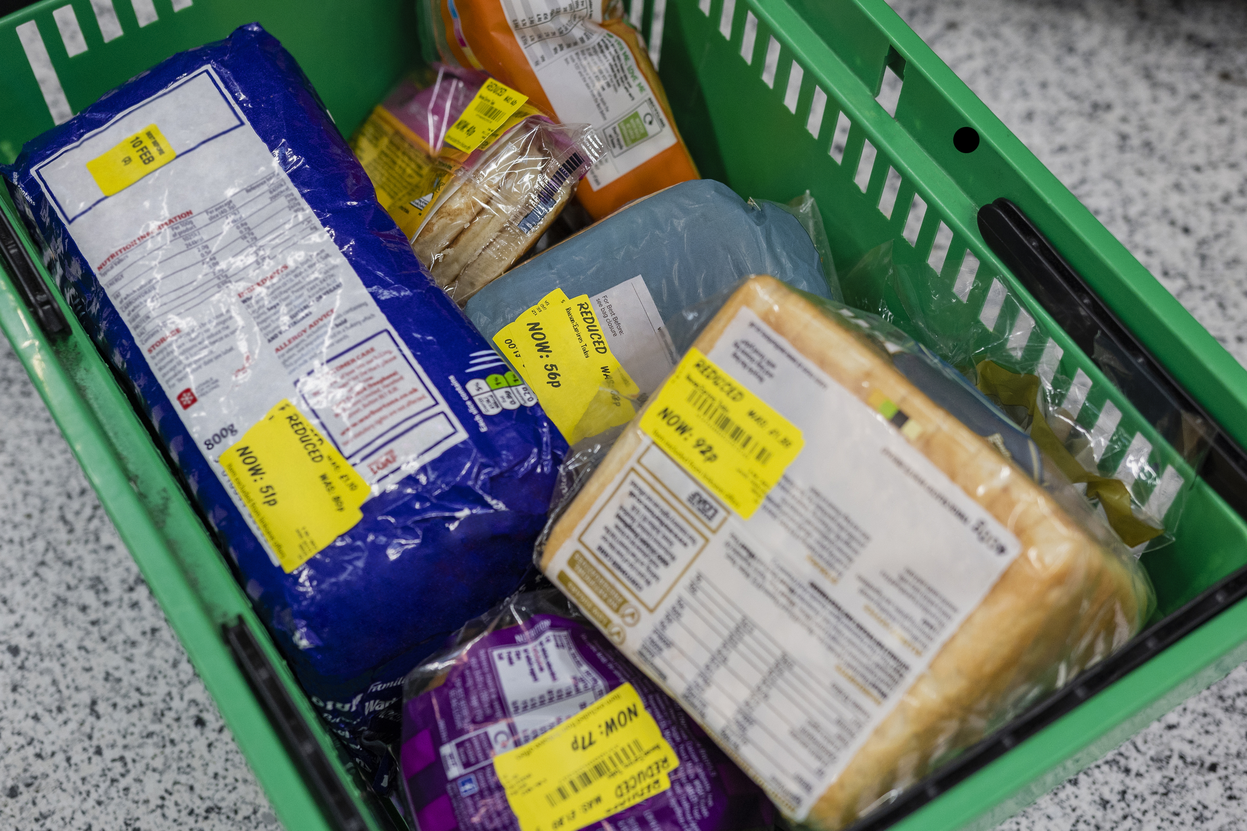 A shopping basket filled with food items with markdown price stickers