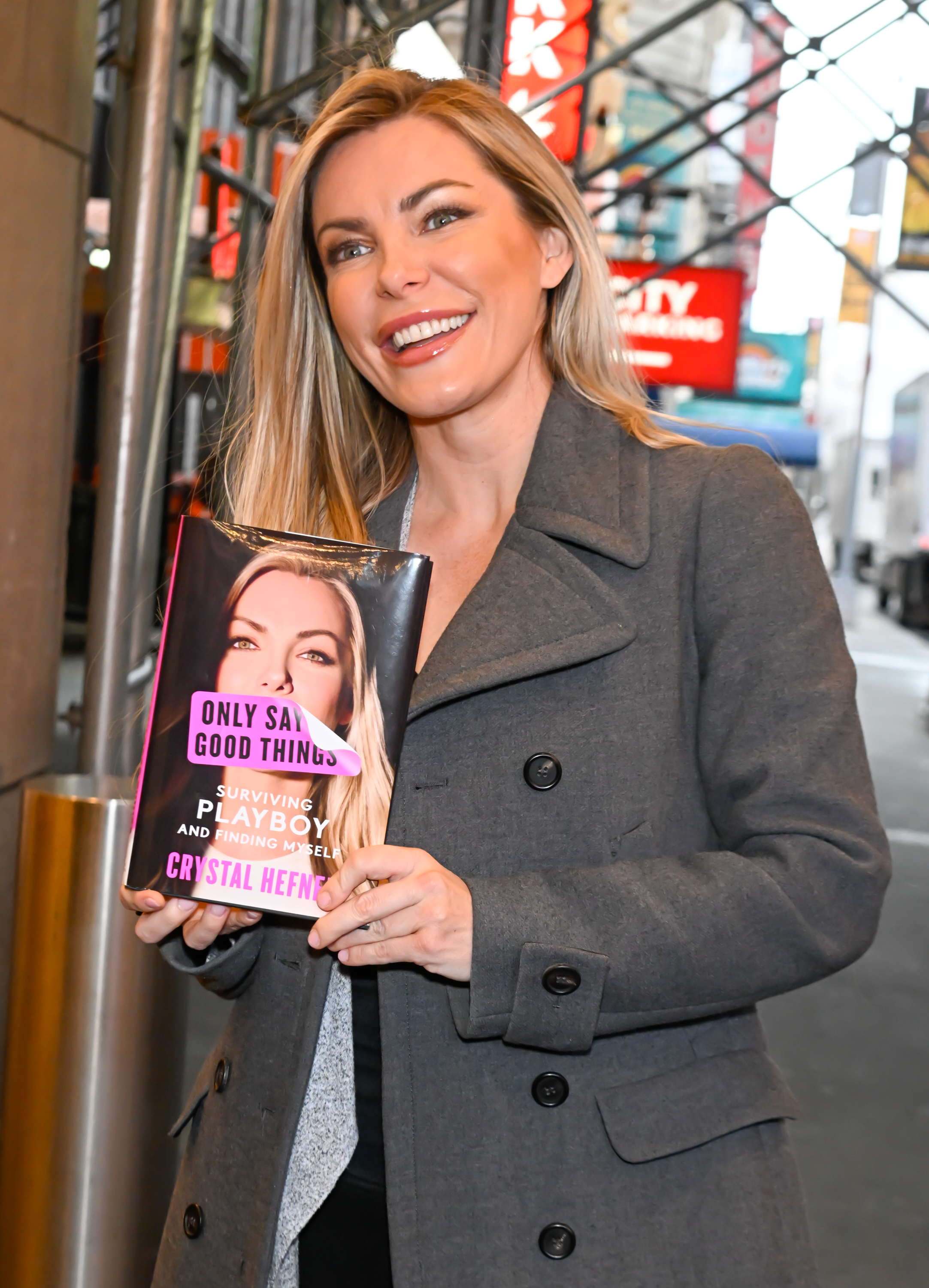 Crystal smiling and holding a copy of her book