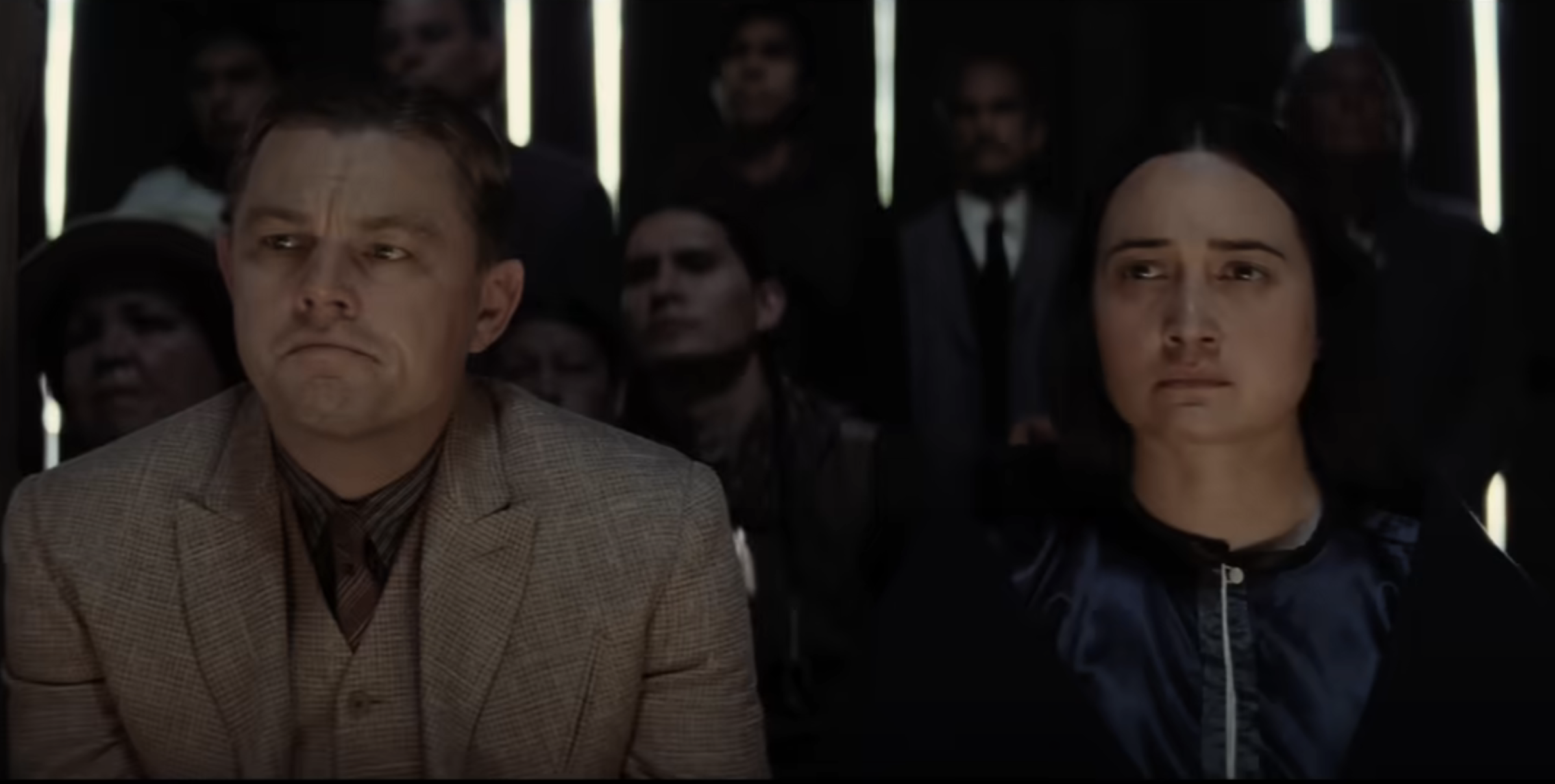 Leo and Lily sitting side by side in a scene from he film
