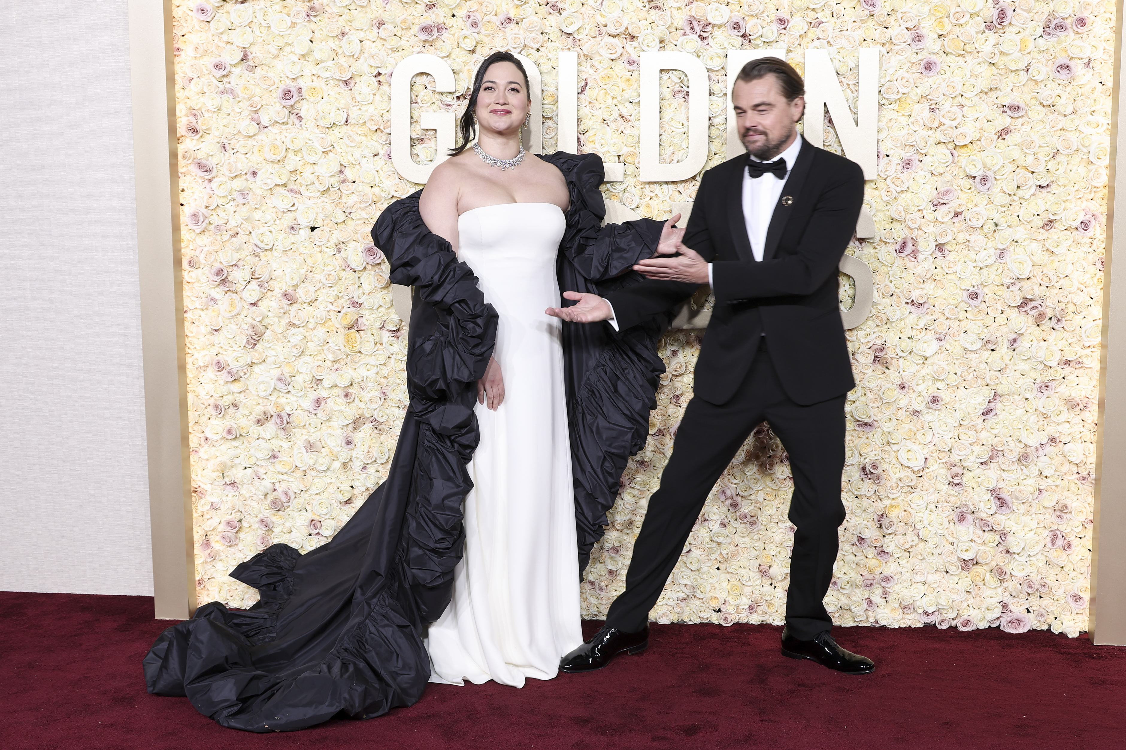 Lily with Leo, who is gesturing toward Lily, on the red carpet