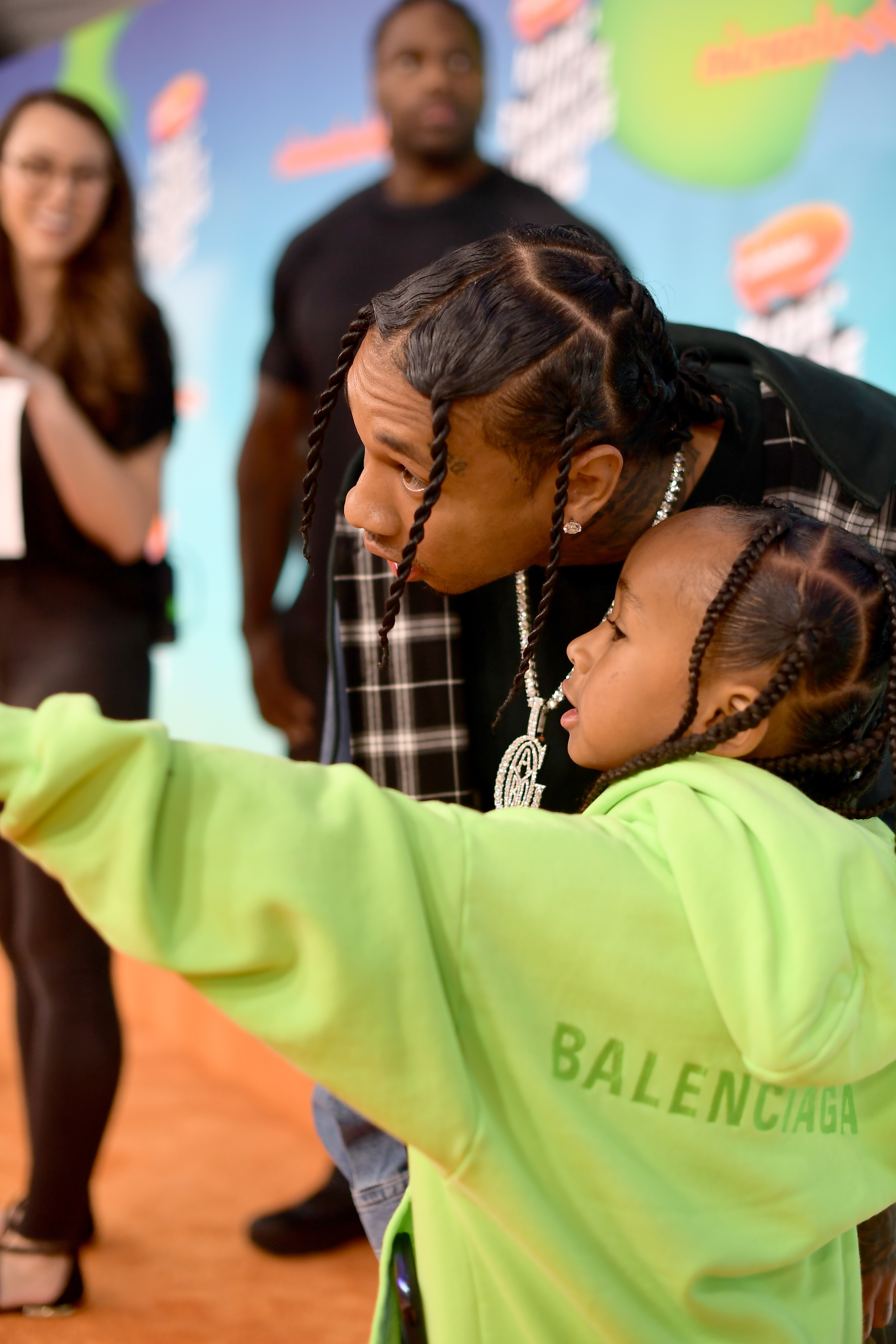 Close-up of Tyga at a media event with one of his children
