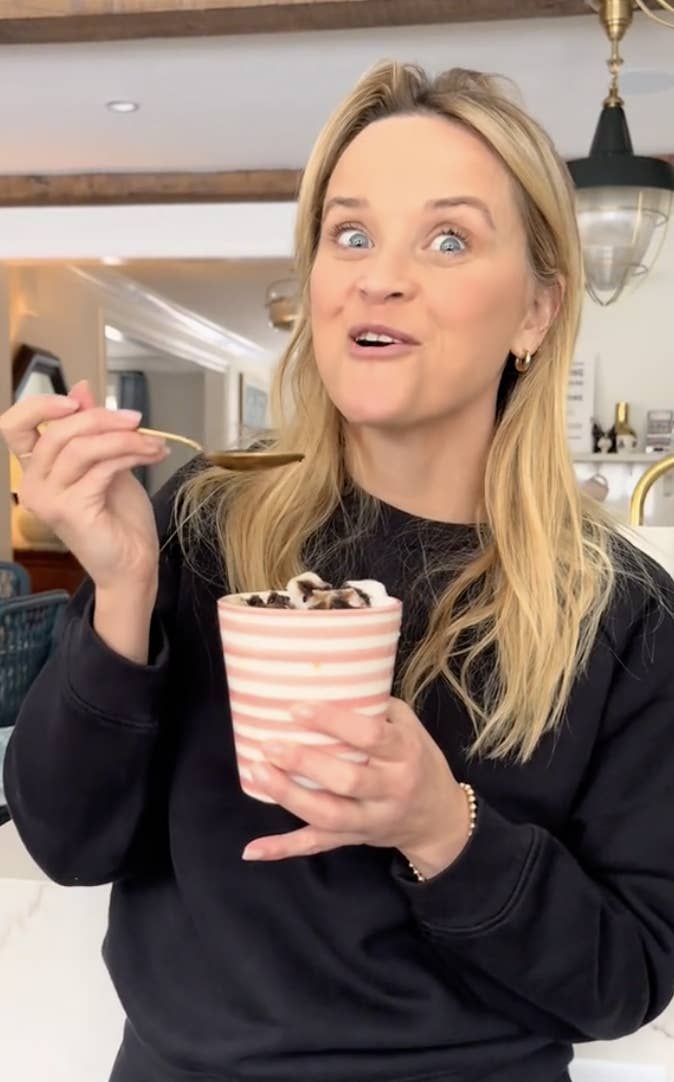 reese witherspoon eating a mug full of her salt snow chococinno