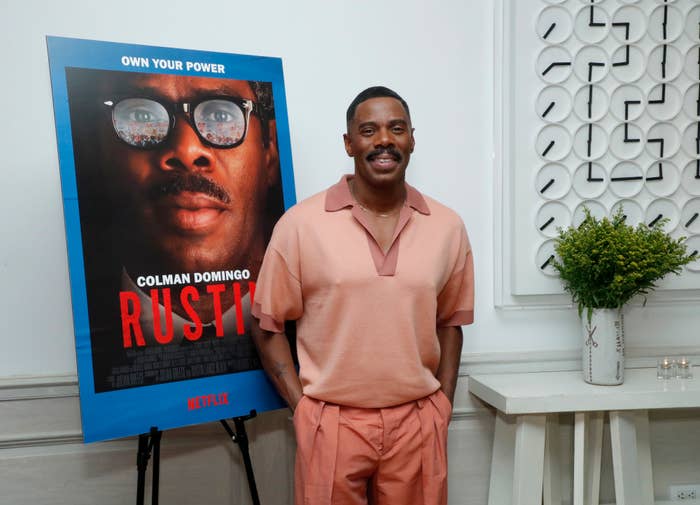 colman domingo in front of movie poster for the film Rustin