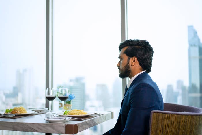 person sitting at a restaurant with a city view behind them