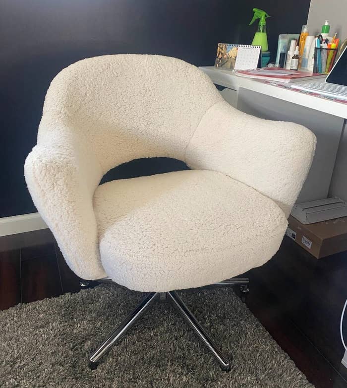 a reviewer photo of the white chair by a desk