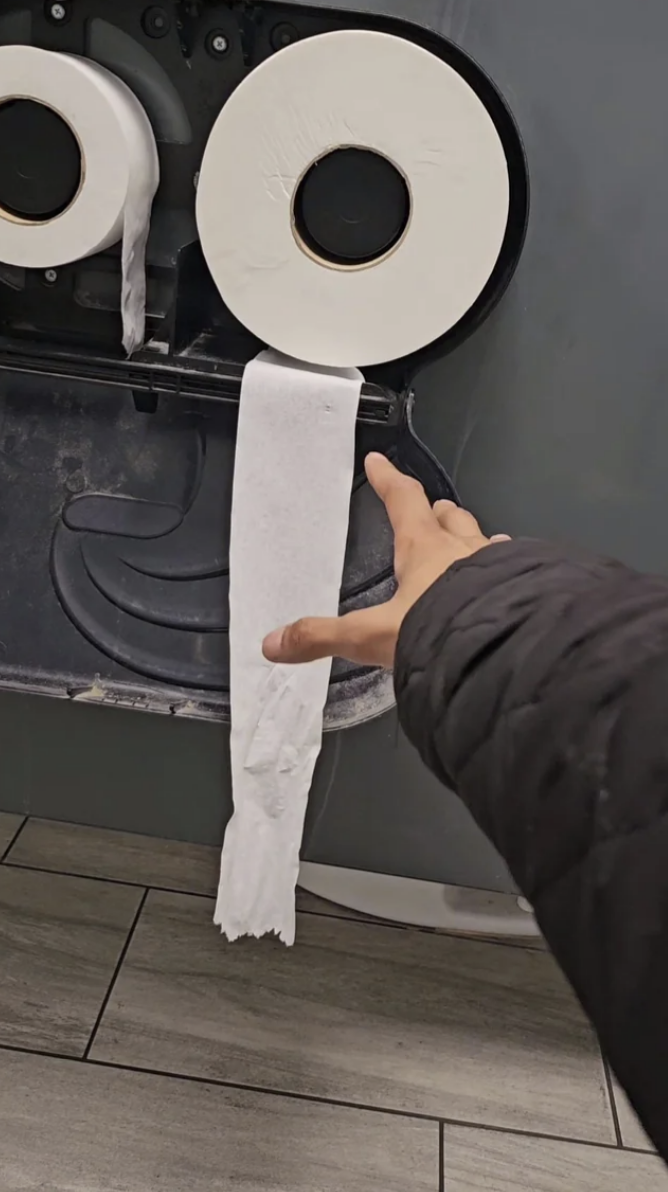 Person reaching for toilet paper that&#x27;s out of reach