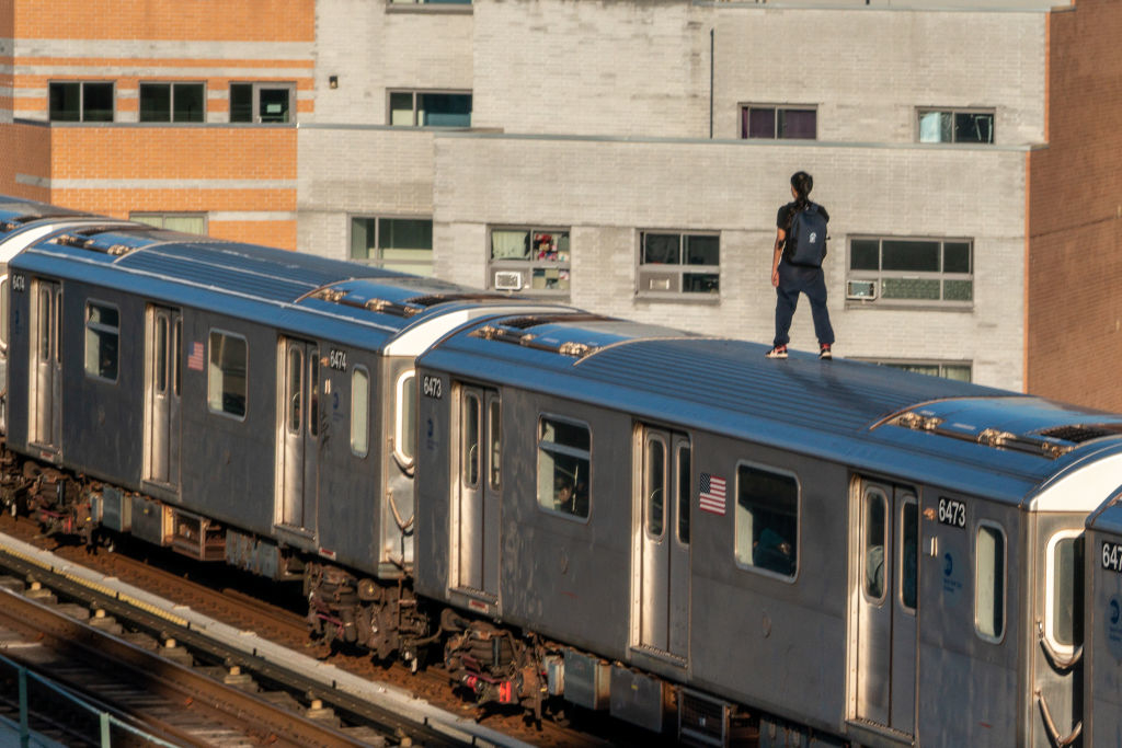 a person standing on top of a subway car