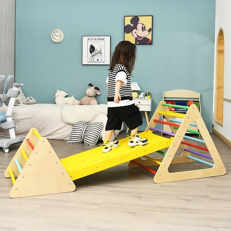 child climbs on wooden play structure