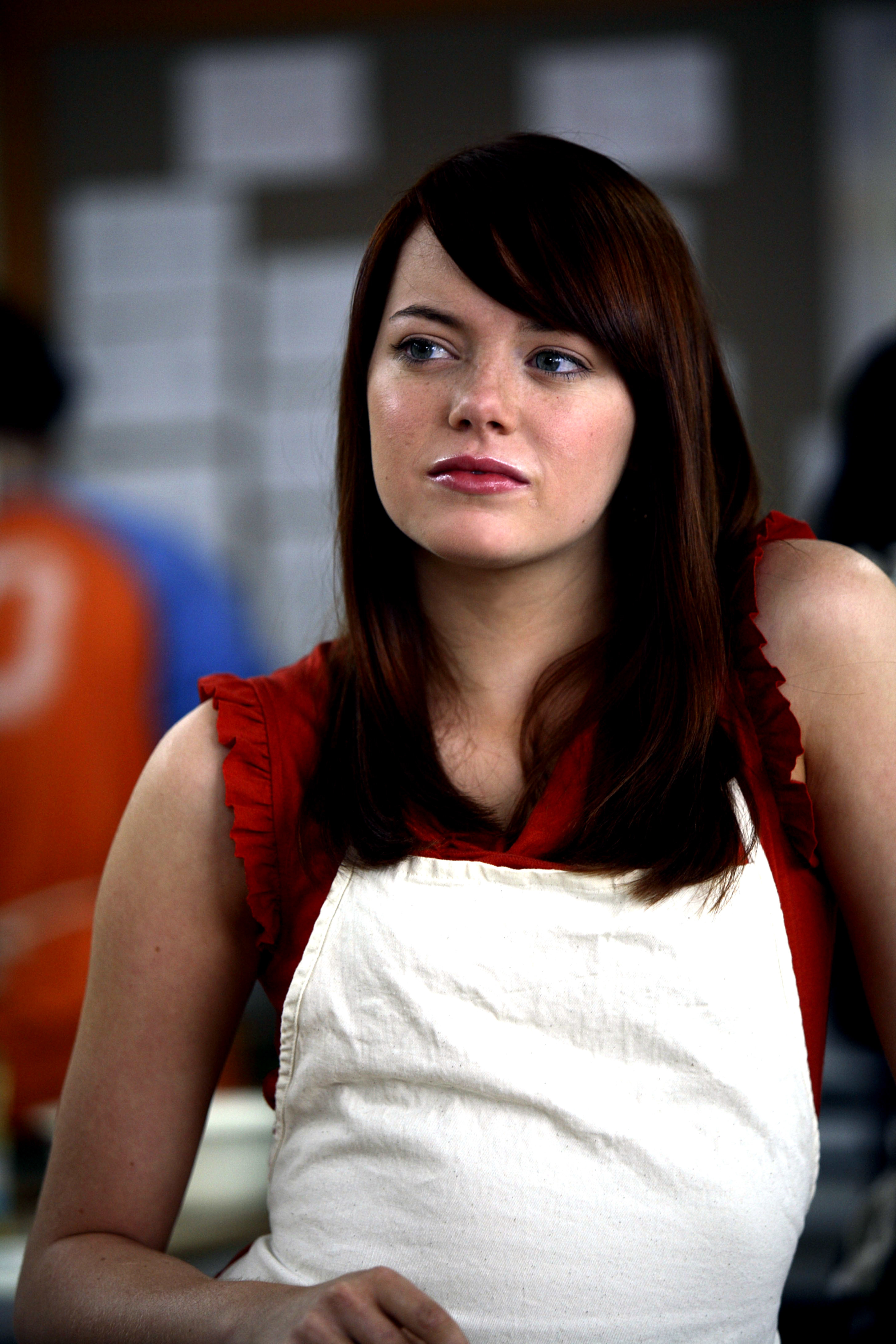 Close-up of Emma in straight hair and side bang and an apron