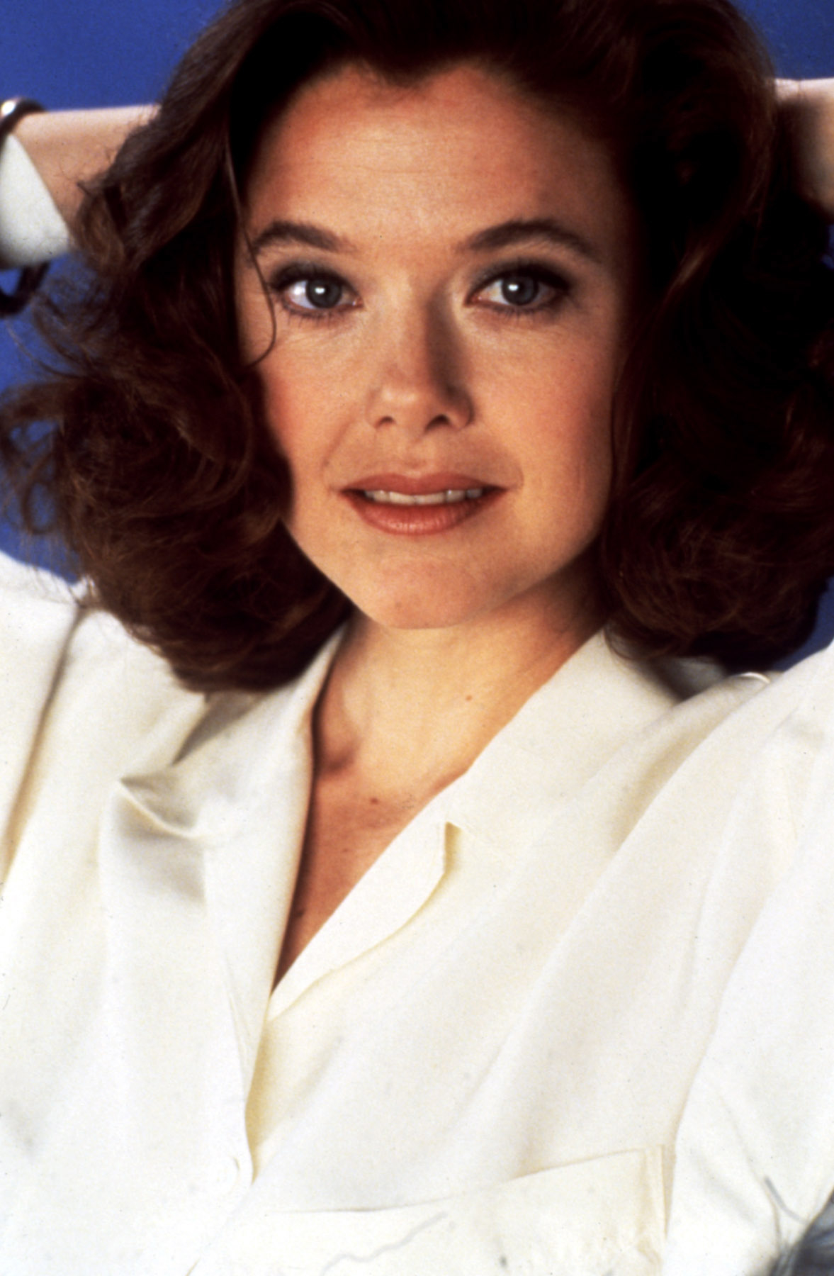 Close-up of Annette with wavy, neck-length hair and wearing a blouse