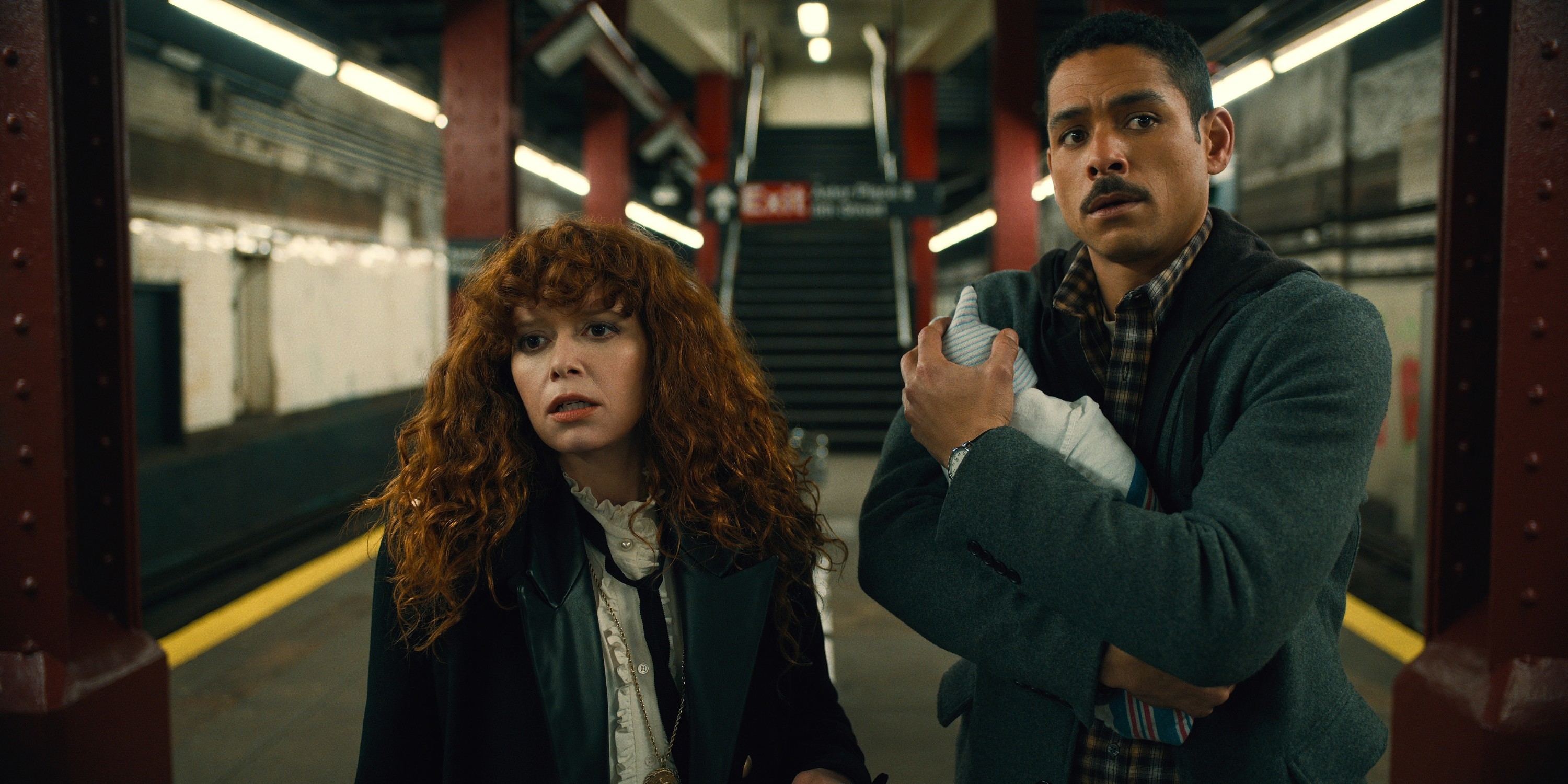 Nadia standing next to a man holding a baby on a subway platform in a scene from &quot;Russian Doll&quot;