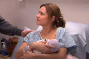 Pam from The Office holding her baby while sitting in a hospital bed