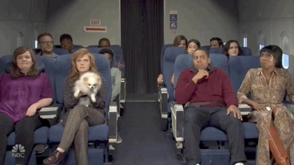 Screenshot from &quot;SNL&quot; of people sitting on a plane