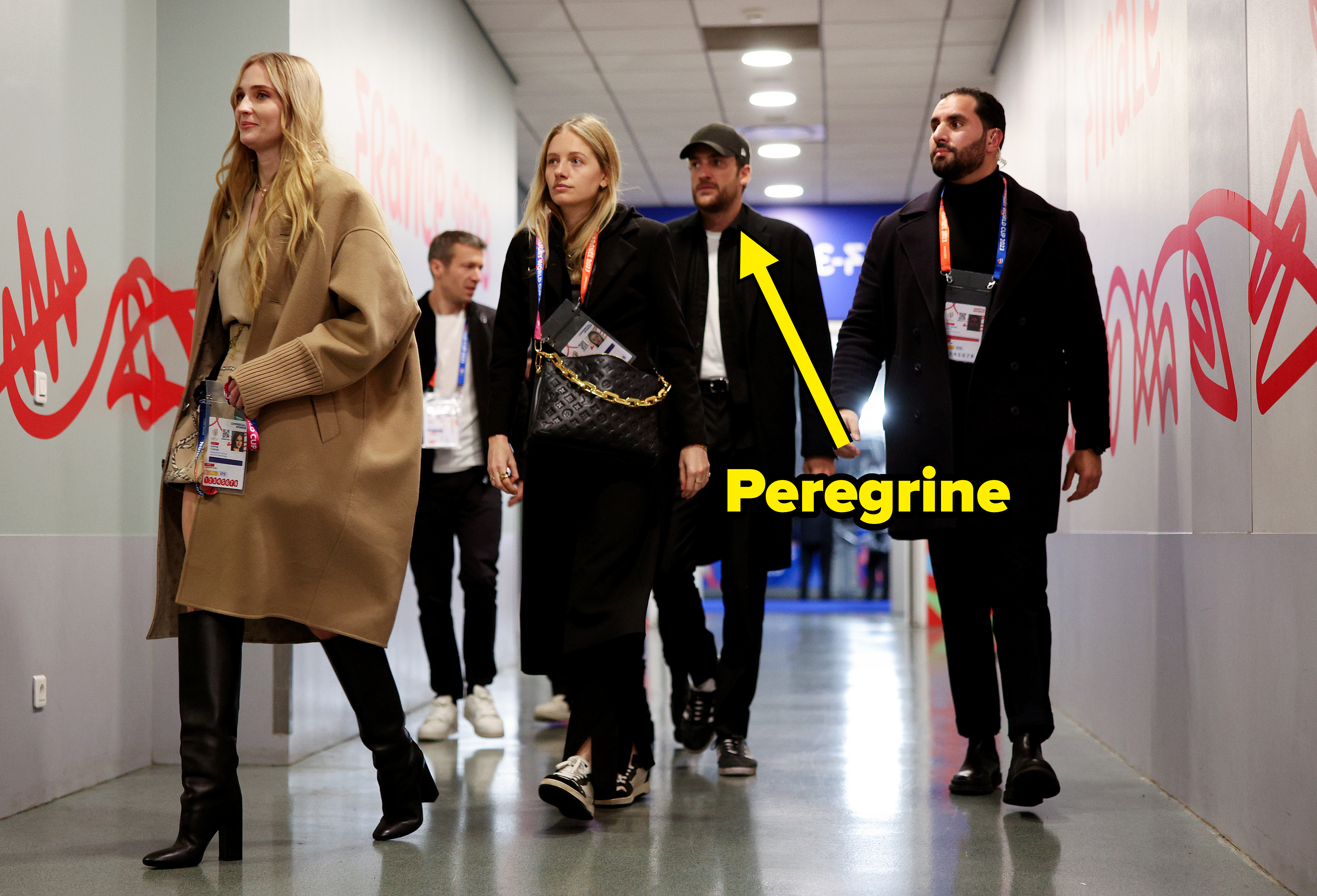 Sophie and Peregrine walking down a hallway with other people